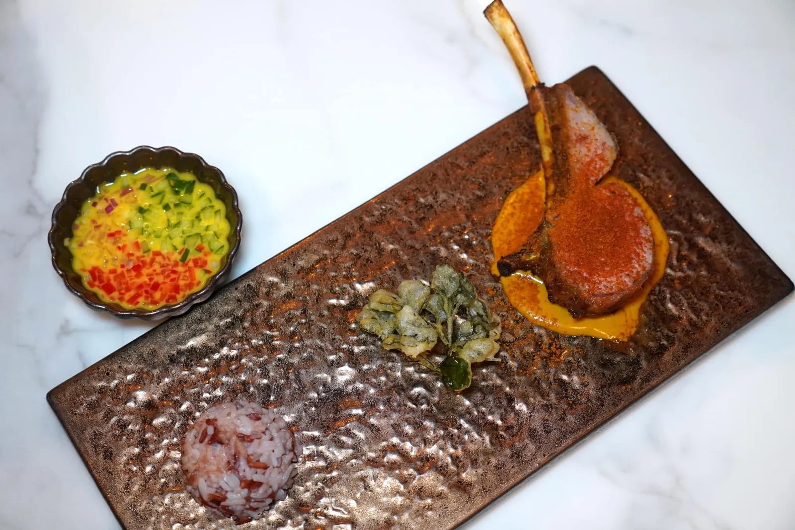 การะเกตถือดาบ (~140 ปี) Grilled Lamb with Karaked Sauce การะเกต เป็นชื่อเมนูจากวังสวนสุนันทาที่พบปรากฎอยู่ในหนังสือโบราณ เชฟเลือกใช้ซี่โครงแกะย่างเสิร์ฟมากับซอสการะเกตที่ขึ้นมาจากขมิ้น กะทิ และกะปิเคยชั้นดี ด้านบนโรยด้วยผงที่เตรียมมาจากน้ำของเนื้อแกะผสมกันกับซอสการะเกตเช่นกัน ตรงกลางคือผักชีครุฑทอดกรอบ ข้างกันคือน้ำอาจาดกะทิจากสูตรของวังสวนสุนันทาสำหรับรับประทานตัดรสชาติกันได้อย่างลงตัว (13/20)