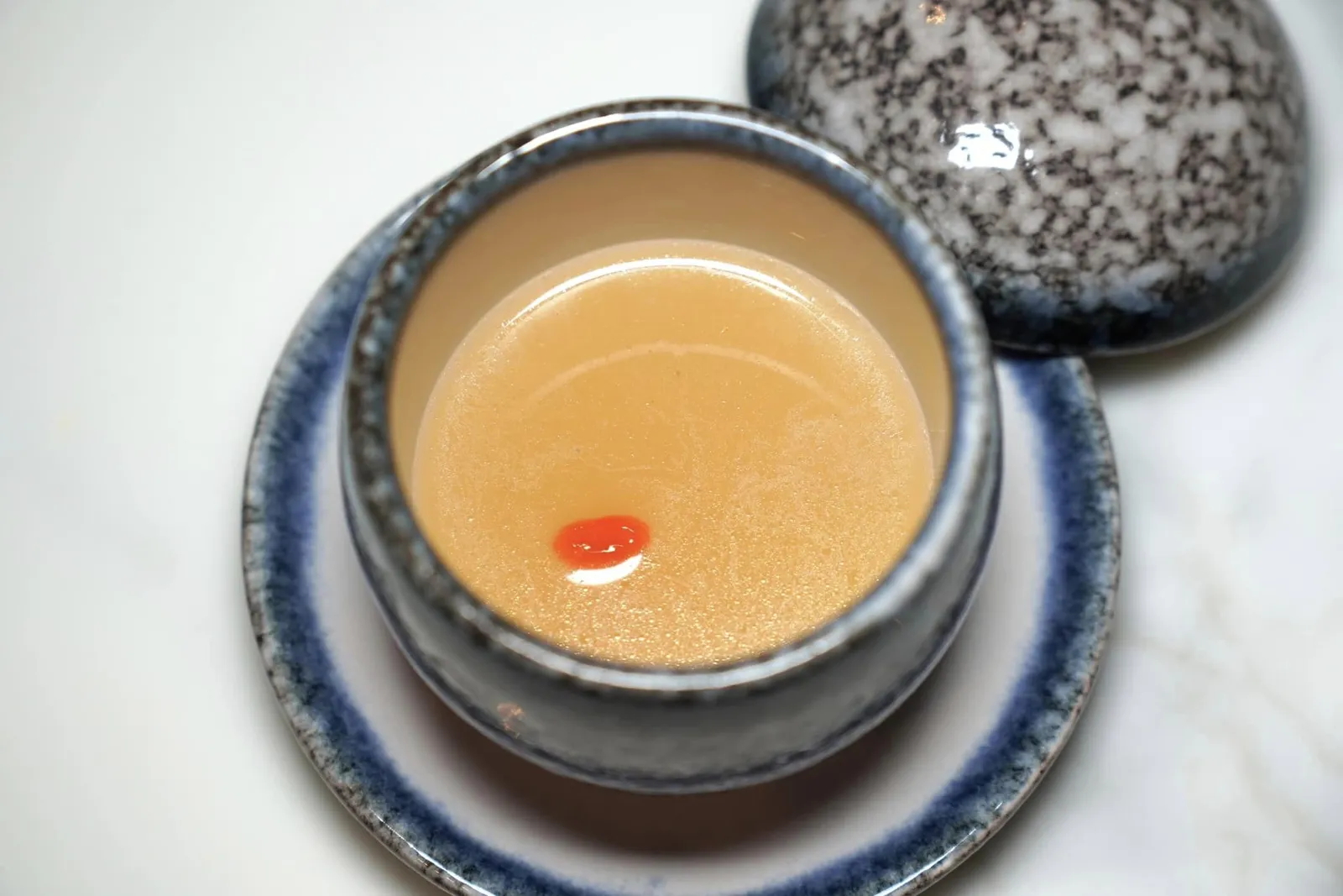 กระยาหารส่งถวาย (ซุปไก่ดำรังนก) (~336 ปี) Bird's Nest in Black Chicken Soup น้ำซุปไก่เสิร์ฟมาในรูปแบบของ Consommé ให้รสชาติที่กลมกล่อม ด้านล่างคือรังนกให้เนื้อสัมผัสกรุบกรอบเสริมด้วยความเปรี้ยวเล็กน้อยของเมล็ดเก๋ากี๊นั่นเอง (13/20)