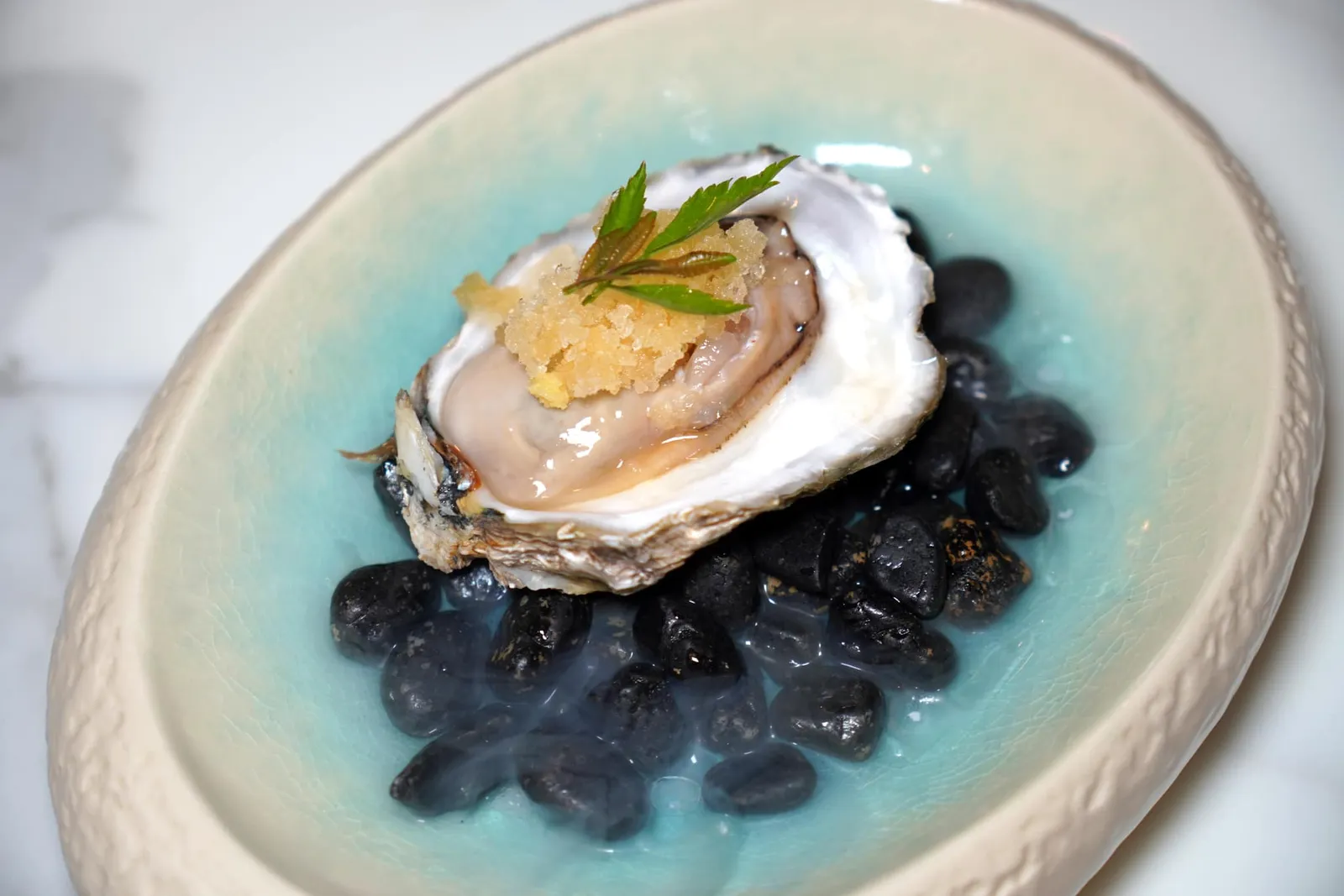 อัมพิละนางรม (หอยนางรมจี๊ดจ๊าด) (~336 ปี) Surat Thani Oyster with Cold Kumquat Tangy Sauce อัมพิละนางรม เป็นเมนูที่ได้บันทึกมาจากบันทึกของซีมง เดอ ลา ลูแบร์ ราชทูตของพระเจ้าหลุยส์ที่ 14 ผู้เดินทางมาประเทศไทยในรัชสมัยสมเด็จพระนารายณ์มหาราชเพื่อเจริญสัมพันธไมตรีกับไทย เชฟเลือกใช้หอยตะโกรมซึ่งเป็นหอยนางรมไซซ์ใหญ่จากจังหวัดสุราษฎร์ธานีจับคู่กับกรานิต้าซิตรัสมะปิ๊ดและขิงขูด ด้านบนท็อปด้วยใบผักชีล้อมและใบมะตูมแขก ทั้งนี้ตัวหอยตะโกรมซึ่งปกติจะมี Earthy Aroma ปนมามากกลับกลับถูกกลบด้วยความเผ็ดของอาหารจานก่อนหน้าได้อย่างลงตัว (12/20)