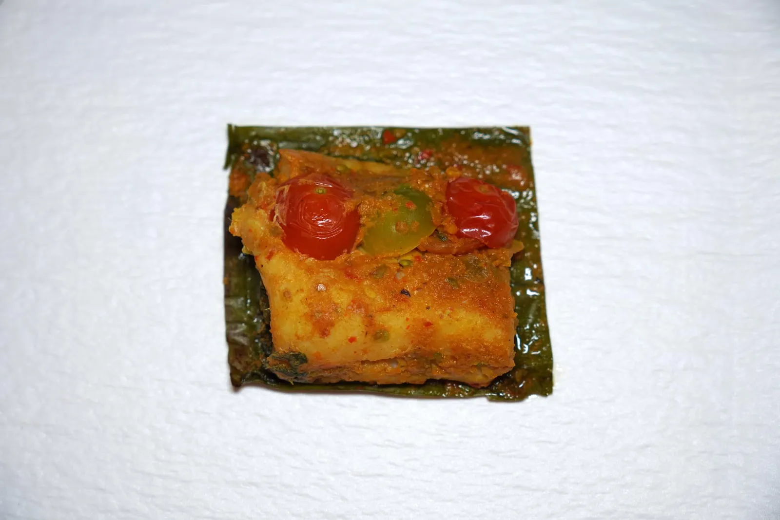 มัจฉาซ่อนรส (งบห่อหมกปลาบู่) (~1,200 ปี) Grilled Marbled Sand Goby Fish Curry in Banana Leaf ในงบยังมีมะเขือเทศที่เรียกกันว่ามะเขือส้ม ด้านล่างรองด้วยใบผักแขยงที่ผ่านการต้มในน้ำกะทิเพื่อลดทอนรสขมแล้วค่อยย่างจนสุกนั่นเอง (13/20)