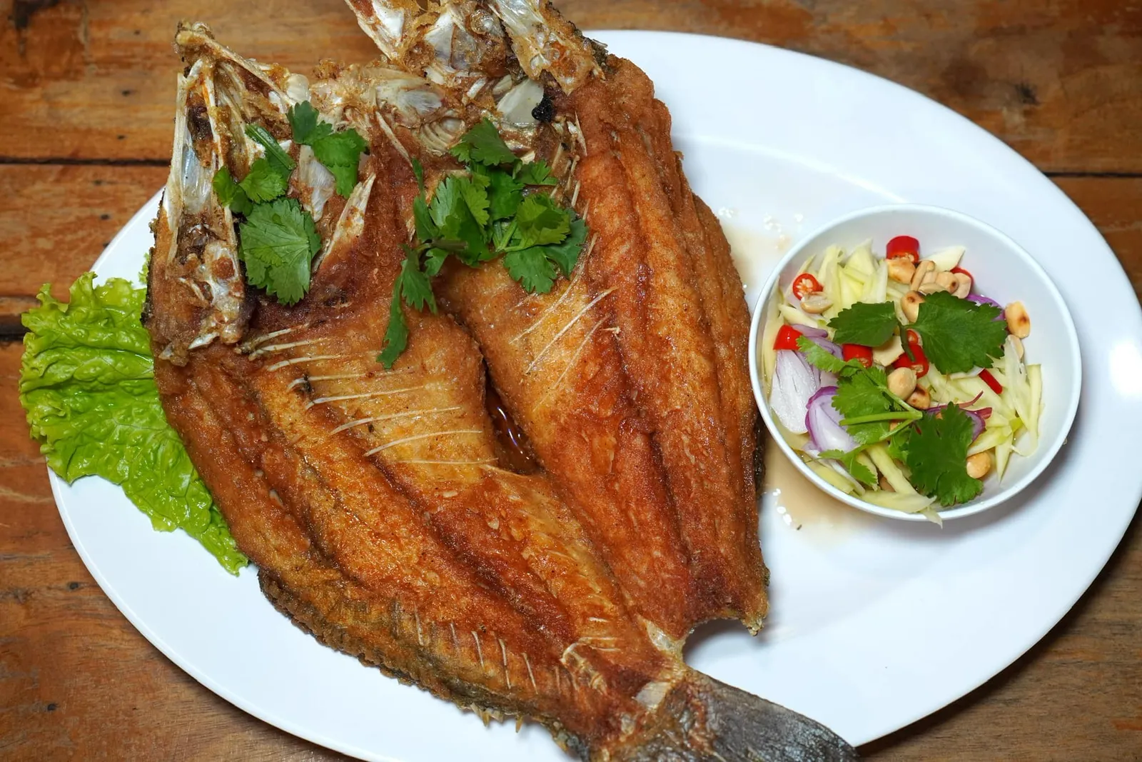 ปลากะพงทอดน้ำปลา (350) Deep Fried White Seabass with Fish Sauce ปลากะพงชิ้นโตทอดสุกเกินไปอยู่บ้างแต่ยังไม่ถึงกับกระด้างเสิร์ฟมากับซอสน้ำปลาและยำมะม่วงข้าง ๆ กัน (11/20)