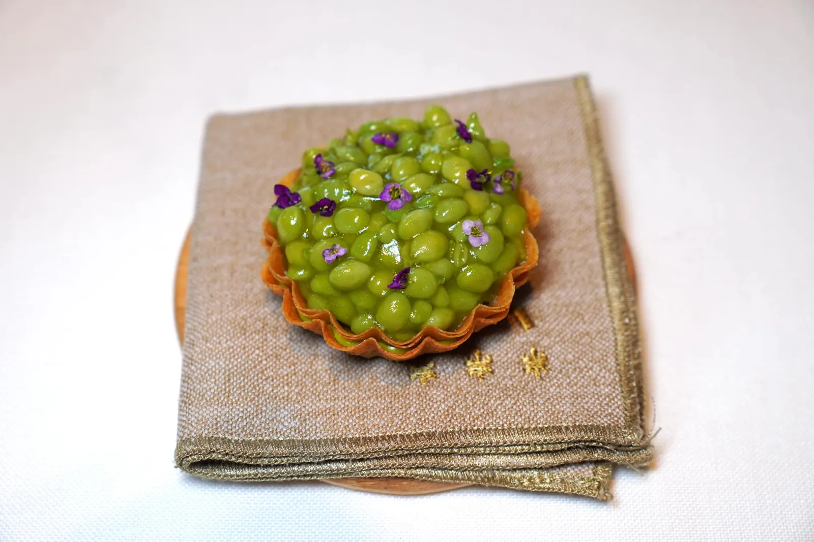 Teardrop PEAS, Iberian gel and fermented pods juice เชฟคัดเลือกถั่วที่ปลูกเองเสิร์ฟมาในทาร์ตเล็ตกรอบ เมล็ดถั่วมีความนุ่มละมุนและให้รสหวานโดยธรรมชาติ รอบ ๆ เคลือบด้วยเจลที่เตรียมมาจากหมูไอบีเรียส่งกลิ่นหอมเฉพาะตัวลอยแตะจมูก ด้านล่างรองด้วยองค์ประกอบของฝักถั่ว (19/20)