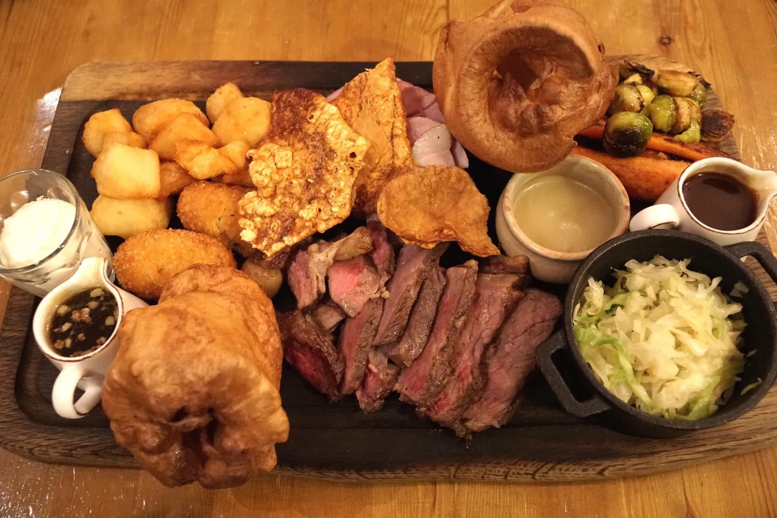Roast rump of Tamworth pork with bramley apple sauce, crackling, roast potatoes and greens และ Roast Sirloin of 45 day aged Hereford beef with Yorkshire pudding, roast potatoes, cauliflower cheese croquettes, horseradish cream, root vegetables, bone marrow gravy and greens (£10 supplement) สำหรับจานหลักจะเสิร์ฟมาเป็นแพลทเทอร์ขนาดยักษ์คู่กันแบบนี้