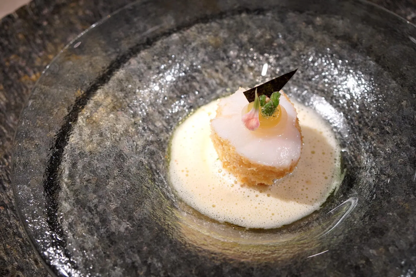 🐟 Monkfish pineapple, nori, macadamia nuts, & dashi butter ปลาม็องฟิชเผา รองด้านล่างด้วยซอสรสเปรี้ยวทำจากส่วนผสมของสับปะรด, ถั่วแมคคาดีเมียร์ และสาหร่ายโนริ ด้านบนคือ pearl onion ทรงกลมที่ใส่น้ำสับปะรดเอาไว้ด้านใน ล้อมรอบด้วย dashi beurre blanc flavorred with curry oil จานนี้เป็นจานของปลาม็องฟิชที่ดีที่สุดเท่าที่เคยทานมา ใครจะคิดว่าปลาม็องฟิชที่รสชาติดีอยู่แล้ว ทางร้านกลับทำให้ดียิ่งขึ้นไปอีก เนื้อปลานุ่ม ละมุนจนแทบละลายในปาก จานนี้ว้าวมากๆจนเรียกได้ว่าเป็นจานปลาที่ดีที่สุดจานหนึ่งเท่าที่เคยทานมาเลยก็ว่าได้ และใครจะคิดว่าปลาม็องฟิชที่ว่ามาทานกับซอสสับปะรดรสเปรี้ยวอ่อนจะตัดรสชาติกันลงตัวขนาดนี้ จานนี้รสชาติอร่อยสมกับเป็นร้านระดับโลกมากๆ (20/20)