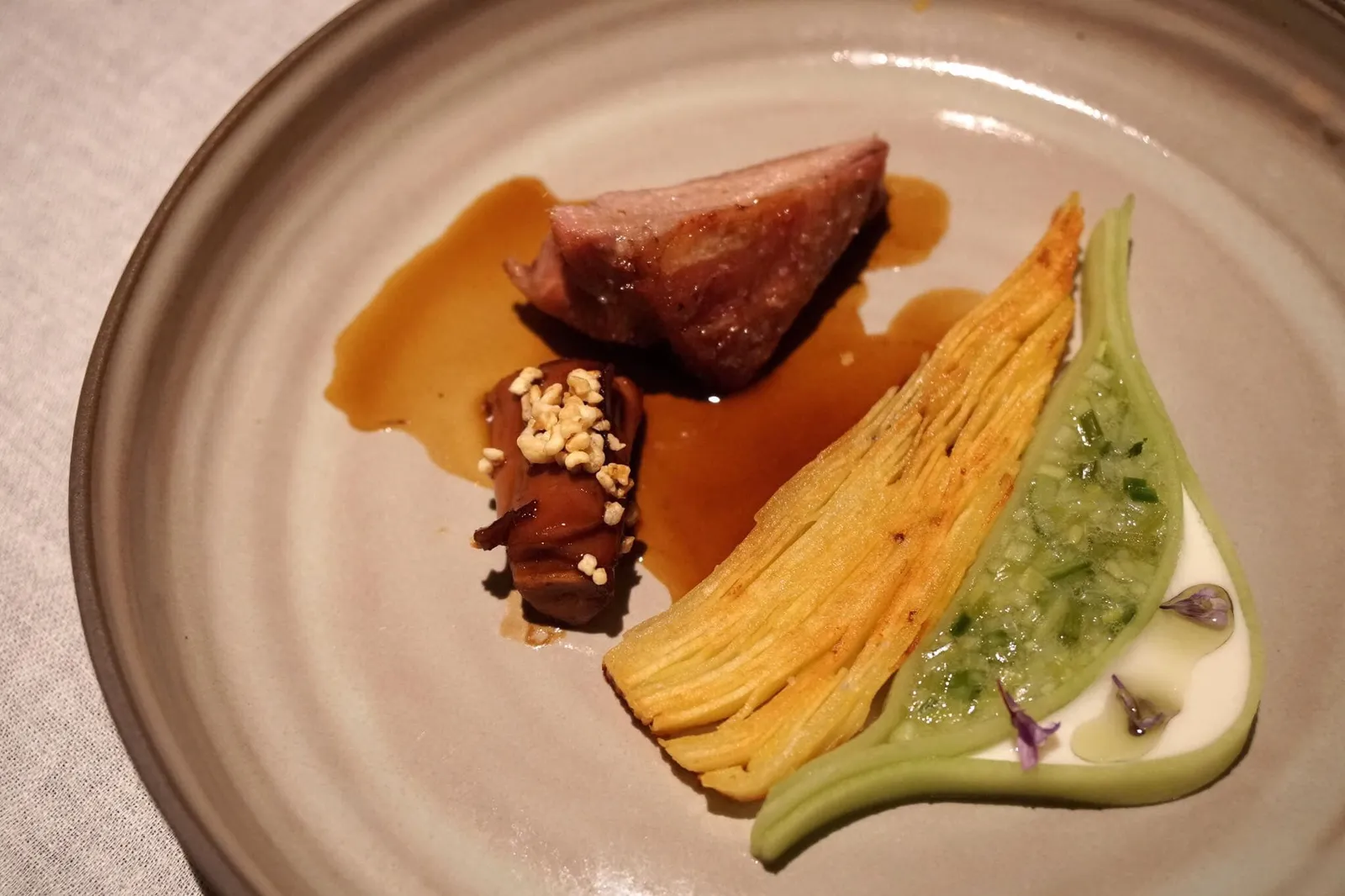 KID GOAT Kid Goat Shoulder with Potatoes, Cucumber & Rosemary Blossom จานนี้ใช้องค์ประกอบหลักเป็น Old Kid Goat หรือเนื้อลูกแพะอายุ 6 สัปดาห์ ซึ่งเป็นช่วงที่ลูกแพะยังไม่กลิ่นสาบ เนื้อชิ้นใหญ่ในรูปคือส่วน Shoulder ของลูกแพะ ทำไปกงฟีและย่างถ่านจนหอม นุ่ม อร่อย เนื้อชิ้นเล็กๆด้านข้างคือ ส่วนข้อเท้าหรือ knuckle ของลูกแพะ นำไปเคี่ยวและเกลซกับธัญพืชบัลเกอร์ปรุงรส ราดด้วยซอสสีน้ำตาลจากเนื้อลูกแพะตุ๋น สีเหลืองคือมันฝรั่งฝานบางทอดกรอบ มีรสหวานกว่าใันฝรั่งทอดทั่วไปที่เราเคยทานมา อร่อยมากๆ ส่วนสีเขียวข้างๆคือสลัดทำจากแตงกวา กระเทียมต้น ถั่วพีสเปร้าท์ พริกไทยอ่อนๆและธัญพืช สีขาวทางขวาสุดคือโยเกิร์ตทำจากดอกโรสแมรี่