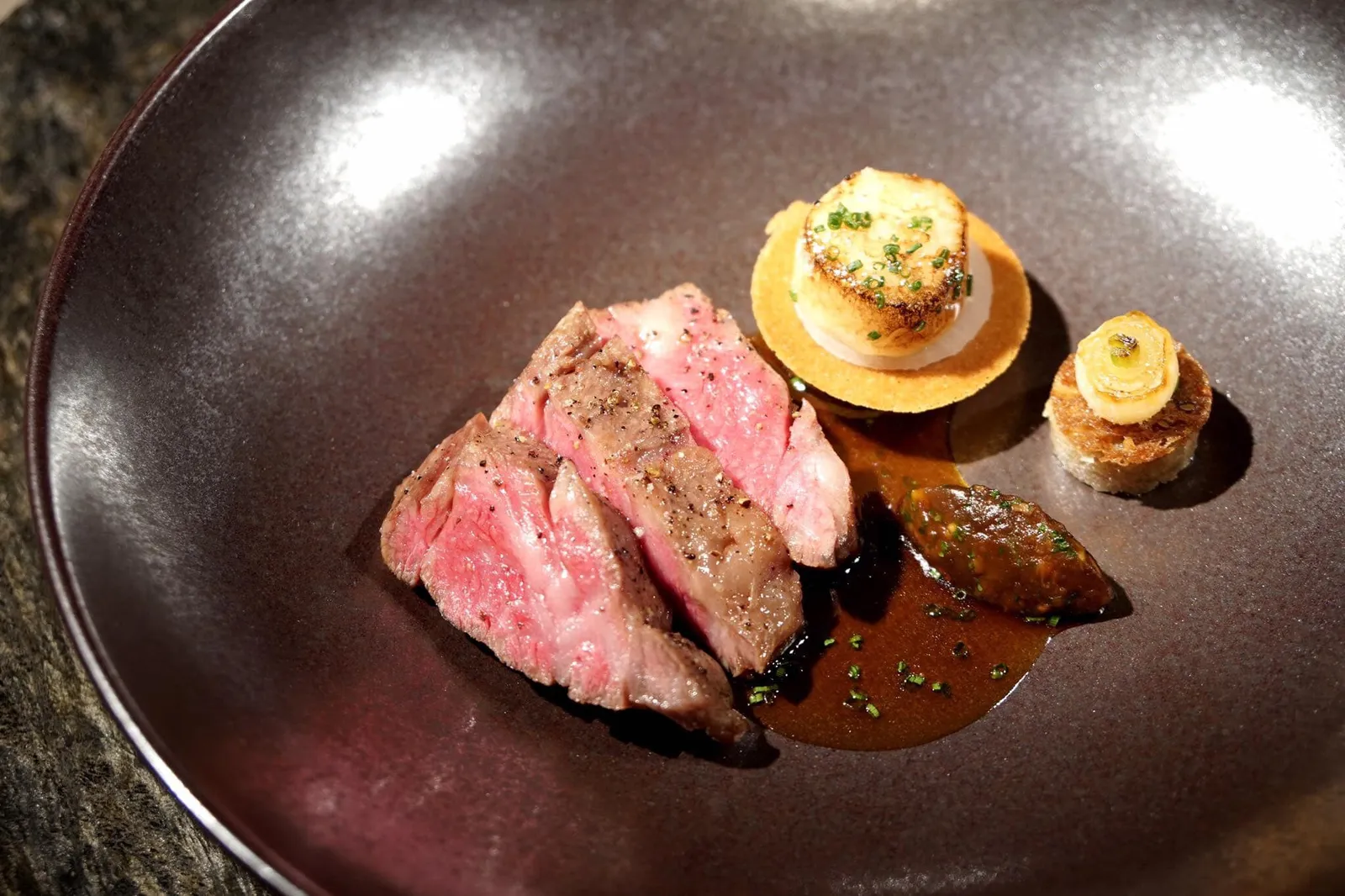 🥩 Kagoshima Wagyu „Chuck Rib“ & marinated marrow eggplant, walnut tapenade, shiitake duxelles & koshihikari สำหรับเมนคอร์สอย่างแรกคือเนื้อวัวคาโกชิมะวากิวส่วนเนื้อซี่โครง นำไปย่างจนสุกระดับมีเดียมแร เนื้อวัวนุ่มมาก ละลายในปาก ไร้ซึ่งกลิ่นตามมาตรฐานเนื้อวากิวคุณภาพสูง ขนาบข้างด้วย marinated beef marrow ทรงกลมด้านข้างมีแรดิช ข้าวโคชิฮิคาริ สมุนไพร และเห็ดชิทาเกะ ทรงกลมชิ้นเล็กทำจากถั่ววอลนัทผสมกับ chives mayonnaise ผสมกับมะเขือยาวและซูคินี่ (18/20)