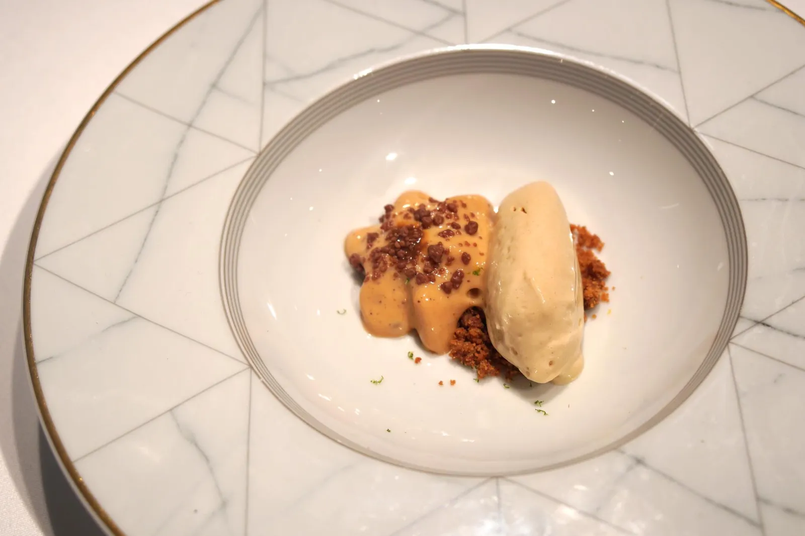 16. Leche asada de cabra con haba tonka, dulce de guayaba y petazetas. Helado de gofio del pais. ขนมหวานจานถัดมาคือไอศกรีมโกฟิโอ้จากหมู่เกาะคานารี มีรสออกหวาน ตอนทานจะมีกลิ่นหอมคล้ายซีเรียล ทานกับนมแพะเผาและถั่วตองกา ข้างล่างมี Guava jelly หรือ Bocadillo เป็นขนมพื้นเมืองของสเปน มีเนื้อสัมผัสเคี้ยวหนึบ นอกจากนี้เชฟยังมีลูกเล่นโดยการใส่ Peta Zatas หรือขนมเป๊าะเเป๊ะบ้านเราที่เวลาเคี้ยวเเล้วจะมีเสียงเเตกเป๊าะเเป๊ะในปากอยู่ในนี้ด้วย ทุกองค์ประกอบเข้ากันได้เป็นอย่างดี จานนี้เชฟเสิร์ฟใ้ห้ทานกับช้อนรูปหัวกะโหลกหน้าตาประหลาด (17/20)
