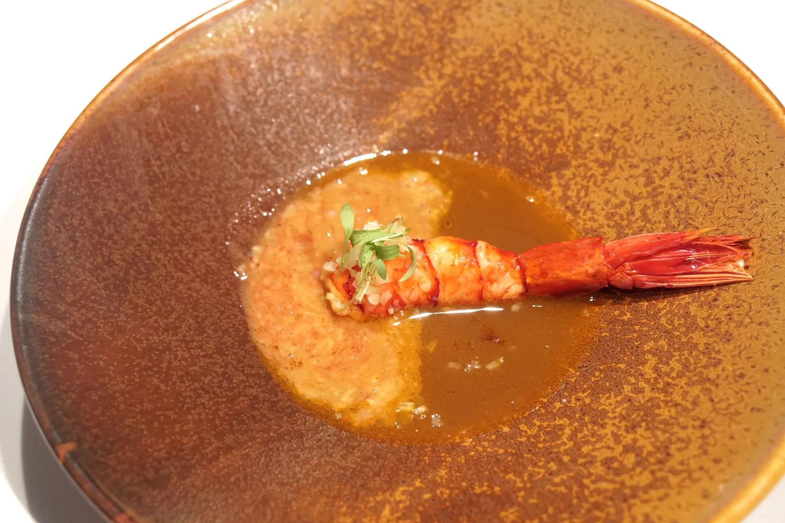11. Potas en salsa con carabinero glaseado y jugo de sus cabezas. ถัดมาคือจานที่ดีที่สุดในค่ำคืนนี้ เริ่มจากซุปที่ทำมาจากหมึก cuttlefish หอมกลิ่นทะเล เสิร์ฟให้ทานคู่กันกับส่วนหาง 2/3 ของกุ้งแดงคาราบิเนโร สุดยอดวัตถุดิบระดับโลกของประเทศสเปนและทะเลเเถบนี้ เนื้อกุ้งมีรสหวานธรรมชาติในระดับที่อร่อยที่สุดเท่าที่กุ้งตัวหนึ่งจะให้ได้ มีความนุ่มเด้งที่พอดีมากๆ ก่อนทานพนักงานจะมาบีบมันกุ้งลงในน้ำซุป มีรสขมอ่อนๆตัดกับรสหวานของเนื้อกุ้ง ฟินมากๆ (17/20)