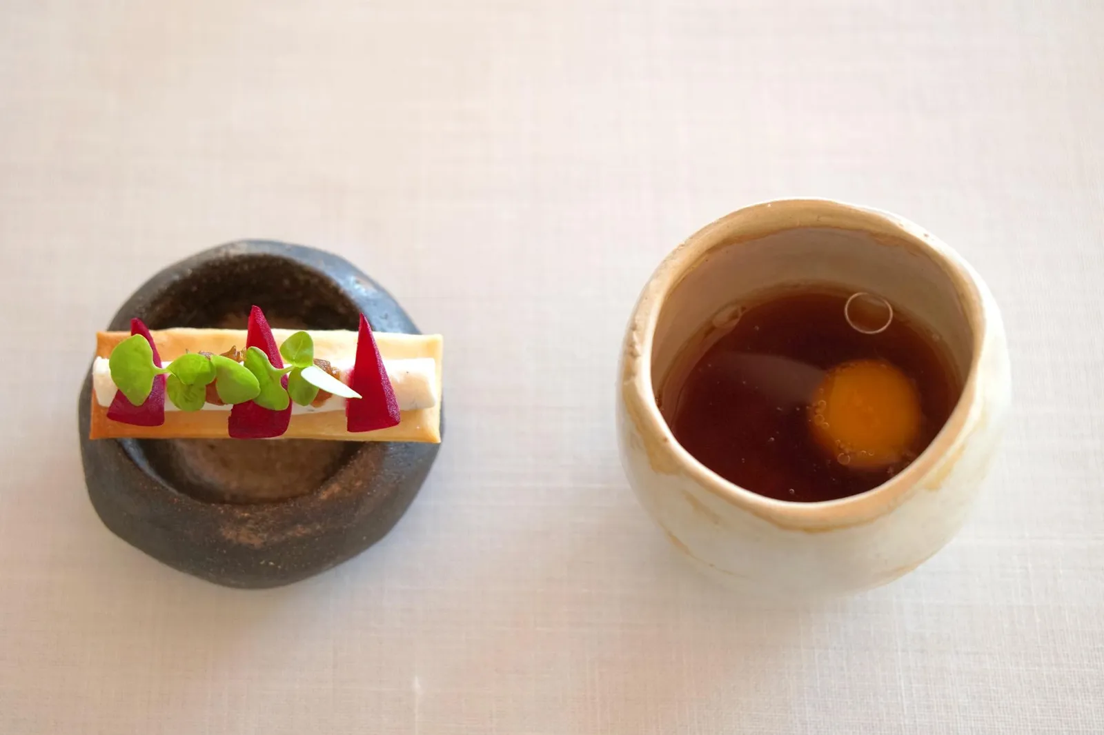 Onion Soup อมูสบูชอย่างแรกทางขวามือคือ sopa de cebolla หรือซุปหัวหอมเสิร์ฟมาอุ่นๆ รสชาติเข้มข้น เค็มๆ เปรี้ยวๆ กลมกล่อม ใช้ช้อนตักข้างล่างจะพบสาคูหรือ tapioca ตอนทานจะเคี้ยวหนึบๆ ตัดเนื้อสัมผัสกันด้วยความนุ่มของไข่แดงที่ได้จากไข่นกกระทา กลิ่นและเนื้อสัมผัสของไข่กับซุปหัวหอมเสริมกันได้อย่างดี เราเองเพิ่งเคยทานซุปหัวหอมกับสาคูเป็นครั้งเเรก ไม่น่าเชื่อว่าจะเข้ากันได้ดีแบบนี้ (16/20) - Olive oil toast with cottage cheese, onion and basil อย่างที่สองทางซ้ายมือคือแป้งน้ำมันมะกอกเคี้ยวกรอบ ทอปด้านบนด้วยคอทเทจชีสเป็นชีสเคิร์ดสีขาว รสชาติเบาๆ ช่วยเชื่อมเนื้อสัมผัสของแป้งกับหัวหอม สีแดงคือหัวหอมรสเปรี้ยวเเละใบเบซิลสีเขียว ทานเเล้วสดชื่นมากๆ (17/20)