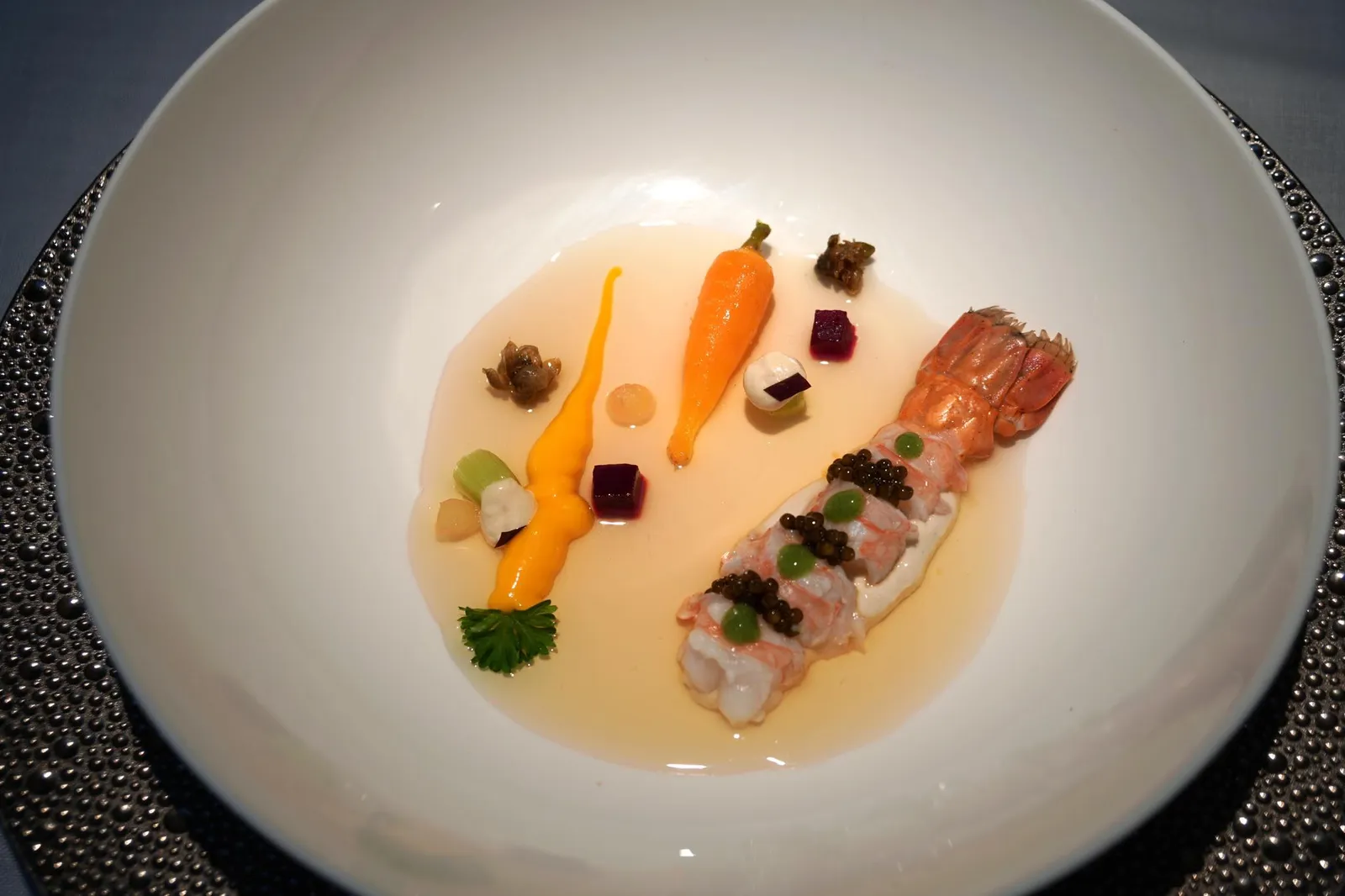 NEPHROPS, marinated vegetables and partridge soup จานนี้มีชื่อในภาษาสเปนว่า Nephrops, escabeche de verduras y consomé de perdiz ซึ่ง Nephrops เป็นกุ้งขนาดเล็ก หรือที่เรารู้จักกันในชื่อภาษาอังกฤษว่า Norway lobster หรือ Dublin Bay prawn หรือ Langoustine นั่นเอง เนื้อกุ้งถูกหั่นมาเป็นส่วน มีความสุกที่พอดีมากๆ มีรสชาติหวานเป็นเอกลักษณ์ ทอปด้านบนด้วยไข่ปลาคาเวียร์ มีรสออกเค็มตัดกับความหวานของกุ้งได้อย่างดี ขนาบข้างด้วยเเครอทและผักดองหรือ pickled แต่ทีเด็ดและความซับซ้อนของจานนี้อยู่ที่น้ำซุปใสทำจากนก (partridge) ที่เมื่อตอนยกมาเสิร์ฟแลดูคล้ายคอนซอมเมแต่หลังจากเทลงในจานแล้วทิ้งไว้ราวๆหนึ่งนาทีตัวซุปจะเซ็ตตัวกลายเป็นเจลหนึบขึ้นมาจนเกิดเนื้อสัมผัสที่เตกต่างกันกับเนื้อกุ้ง สุดยอดมากๆ (20/20)