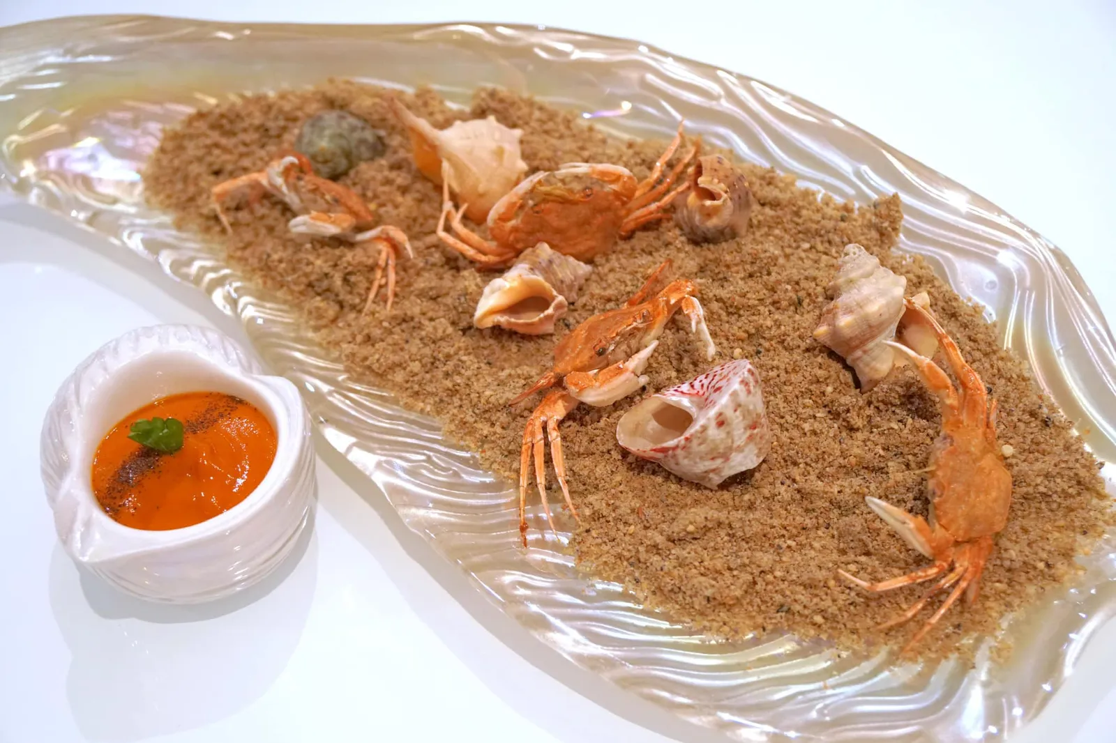 Small rock crabs to dip in the “Salmorreta” sauce. ถัดมาคือ Rock crabs ปูขนาดจิ๋วที่อาศัยอยู่ตามโขดหินจากทะเลเมือง Dénia เสิร์ฟมากับทรายทานได้ทำมาจากดอกไม้ ข้างๆกันคือซอสซัลโมเรตต้า เป็นซอสพื้นเมืองของแถบวาเลนเซียและอลิคานเต้ มีส่วนผสมของมะเขือเทศและพริกหวาน มีรสเผ็ดอ่อนๆ ทางร้านให้นำปูจิ้มลงไปในซอสเเละทานทั้งตัว ส่วนเปลือกหอยเป็นของจริง ทานไม่ได้นะ ! (16/20)