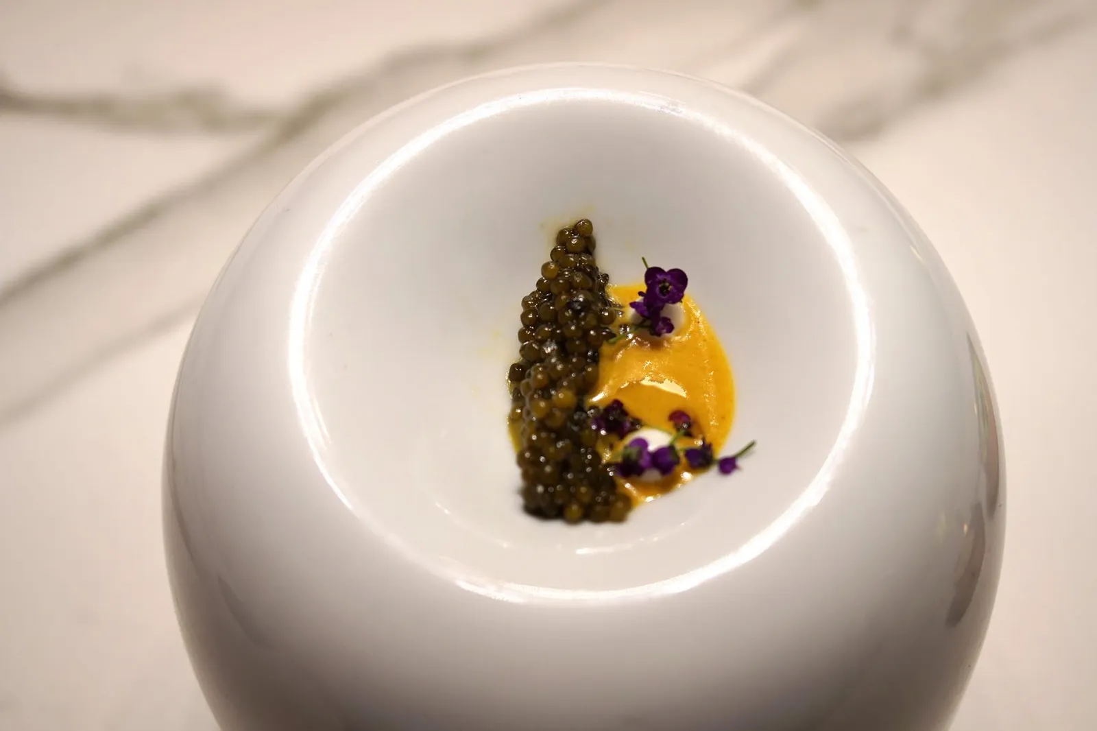 ROASTED CAVIAR IN A “TANDOORI” OVEN WITH “VINDALOO” CURRY AND GREEK YOGURT. ไข่ปลาคาเวียร์ที่เชฟนำไปย่างในเตาทันดูร์เป็นระยะเวลาสั้นๆเพียง 10 วินาที เสิร์ฟให้ทานคู่กันกับเเกงวินดาลูที่มีส่วนผสมของกระวาน, ซินนามอน และมัสตาร์ด ทอปด้านบนด้วยสเฟียร์ทำจากกรีกโยเกิร์ต ไข่ปลาคาเวียร์มีความหนึบมากขึ้นจากการผ่านความรัอนทานเข้ากันได้กับแกงวินดาลูที่มีกลิ่นหอมของแกงอินเดียชัดเจน (20/20)