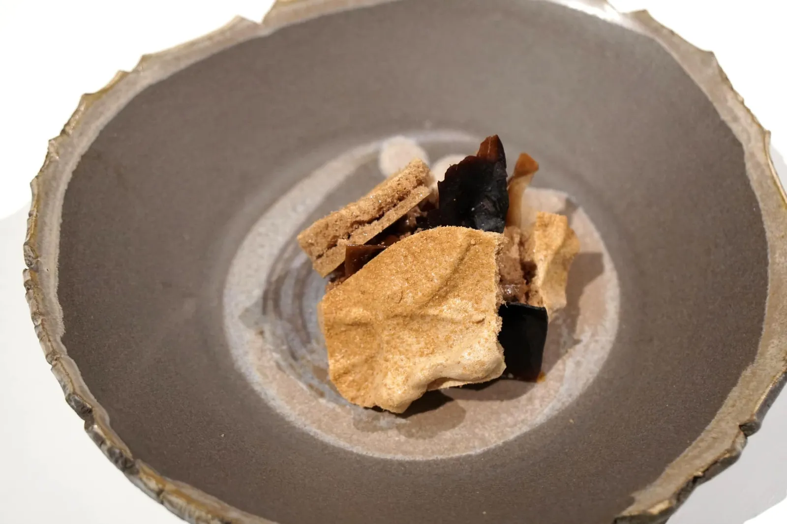 Gianduja of carob and sheep guirra milk. - Caramelized pod. อาหารจานสุดท้ายในห้องทานอาหารหลักคือ Carob หรือคารอบ พืชในวงศ์ถั่วที่พบได้มากในเเถบทะเล Mediterranean มีรสชาติคล้ายโกโก้ที่มีความเย็นของมิ้นท์ ทางร้านนำมาทำเป็นเมอแรงก์ด้านบน มี Gianduja ของคารอบผสมกับนมเเกะสายพันธุ์ Guirra ด้านล่างมีเมล็ดใสๆทำมาจากขิง องค์ประกอบอื่นๆในจานได้เเก่ของ Cacao และกาแฟ (18/20)