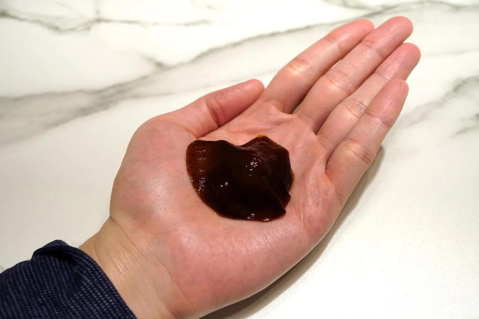 TRIP TO TSUKIJI MARKET... "SEA URCHIN ON THE HAND" WITH FINGER LIME. A VEIL OF "LIQOURICE-BLACK GARLIC" JAPANESE BEARNAISE SAUCE AND BERGAMOT SCENT. เริ่มจากการวางไข่หอยเม่นลงบนมือซึ่งเป็นไข่หอยเม่นสดๆ ไม่มีการปรุงเเต่งรสชาติใดๆ จากนั้นใส่คาเวียกลมๆทำจากมะนาวนิ้วมือหรือ Finger lime จากประเทศ Australia ลงไปเพื่อเพิ่มรสเปรี้ยว ปิดด้วยแผ่นเจลสีน้ำตาลเข้มทำจาก Black garlic ผสมกับเหล้าเบาๆ (20/20)