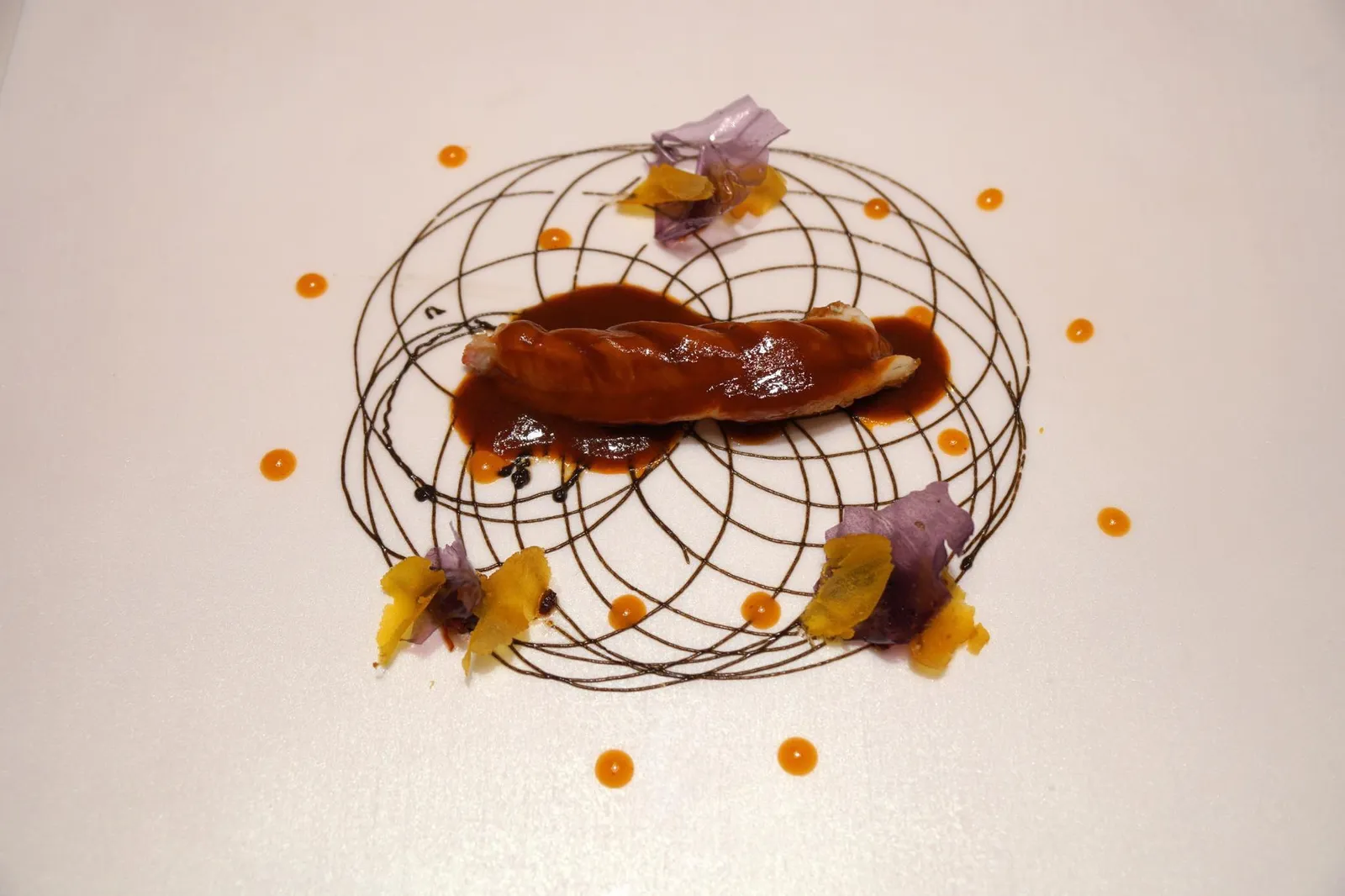 ROASTED LANGOUSTINE SERVED WITH ITS BORDELAISE SAUCE, BLACK GARLIC BUTTER, KIMCHI, XO SAUCE AND BOTAGAR. หนึ่งในจานซิกเนเจอร์ของร้านที่ถูกจัดอยู่ในเมนูอยู่ตลอดคือกุ้งเเลงกูสทีนเผา เสิร์ฟมากับเนยกระเทียมดำหรือเส้นสีดำในภาพ ซอสกิมจิสีส้มมีรสออกเปรี้ยวจากเกาหลี ซอสเอ็กซ์โอและไข่ปลาหมักหรือบอททาการ์รสเผ็ดๆเค็มๆจากจีน และซอสบอเดอเลสเนื้อเนียนที่มีส่วนผสมของมันจากหัวกุ้งและไวน์แดงจากฝรั่งเศส นอกจากนี้ยังมีเวเฟอร์มันฝรั่งเพิ่มความกรอบให้กับจาน ความหวานธรรมชาติของเนื้อกุ้งทานสลับกับซอสต่างๆเข้ากันได้อย่างดี รสชาติของอาหารเเต่ละคำจะเเตกต่างกันไปเล็กน้อยขึ้นอยู่กับปริมาณซอสเเต่ละชนิดที่เราได้ทานเข้าไป (18/20)