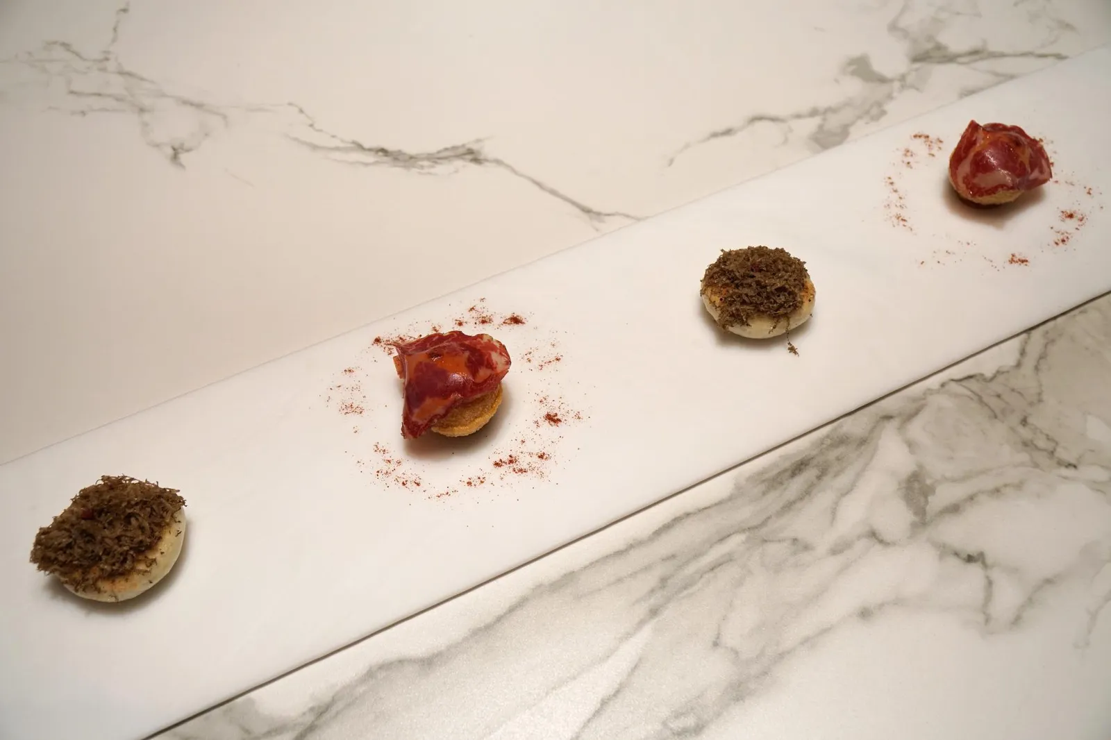 “PANI PURI” FILLED WITH NEW DELHI “SALMOREJO” AND “JOSELITO’S COPPA”. และ STEAMED CHEESE “NAAN” WITH TRUFFLE, CORN AND ACIDULATED PARMESAN CHEESE. ถูกจัดเสิร์ฟมาในบอร์ดยาวใหญ่