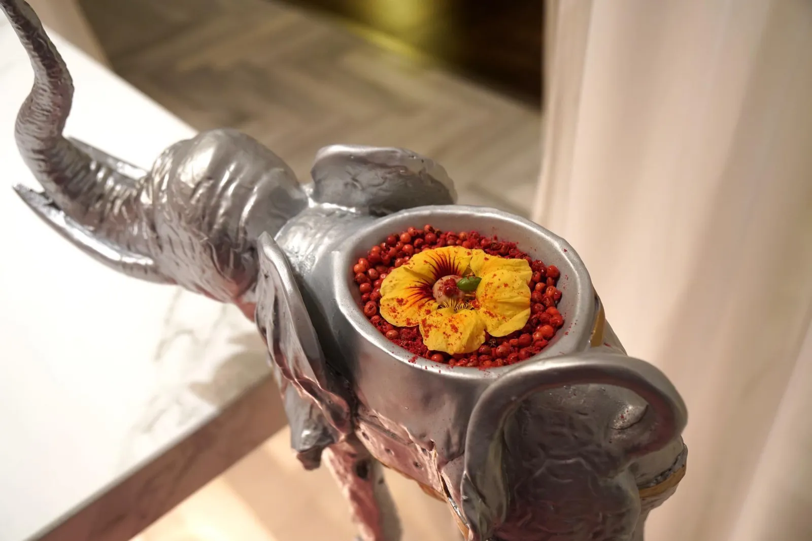 MUMBAI FLOWER WITH PINK PEPPER. ปิดท้ายอาหารอินเดียคอร์สใหญ่ด้วยดอกไม้อินเดีย โรยด้านบนด้วยพริกไทยแดง เสิร์ฟมาบนหลังของรูปปั้นช้างสีเงิน ตัวดอกไม้มีรสออกเปรี้ยวๆ แซด้วยรสเผ็ดเบาๆเเละกลิ่นหอมจากพริกไทย ทานเเล้วรู้สึกสดชื่นเเละดับคาวอาหารจานก่อนหน้าได้ดี (18/20)