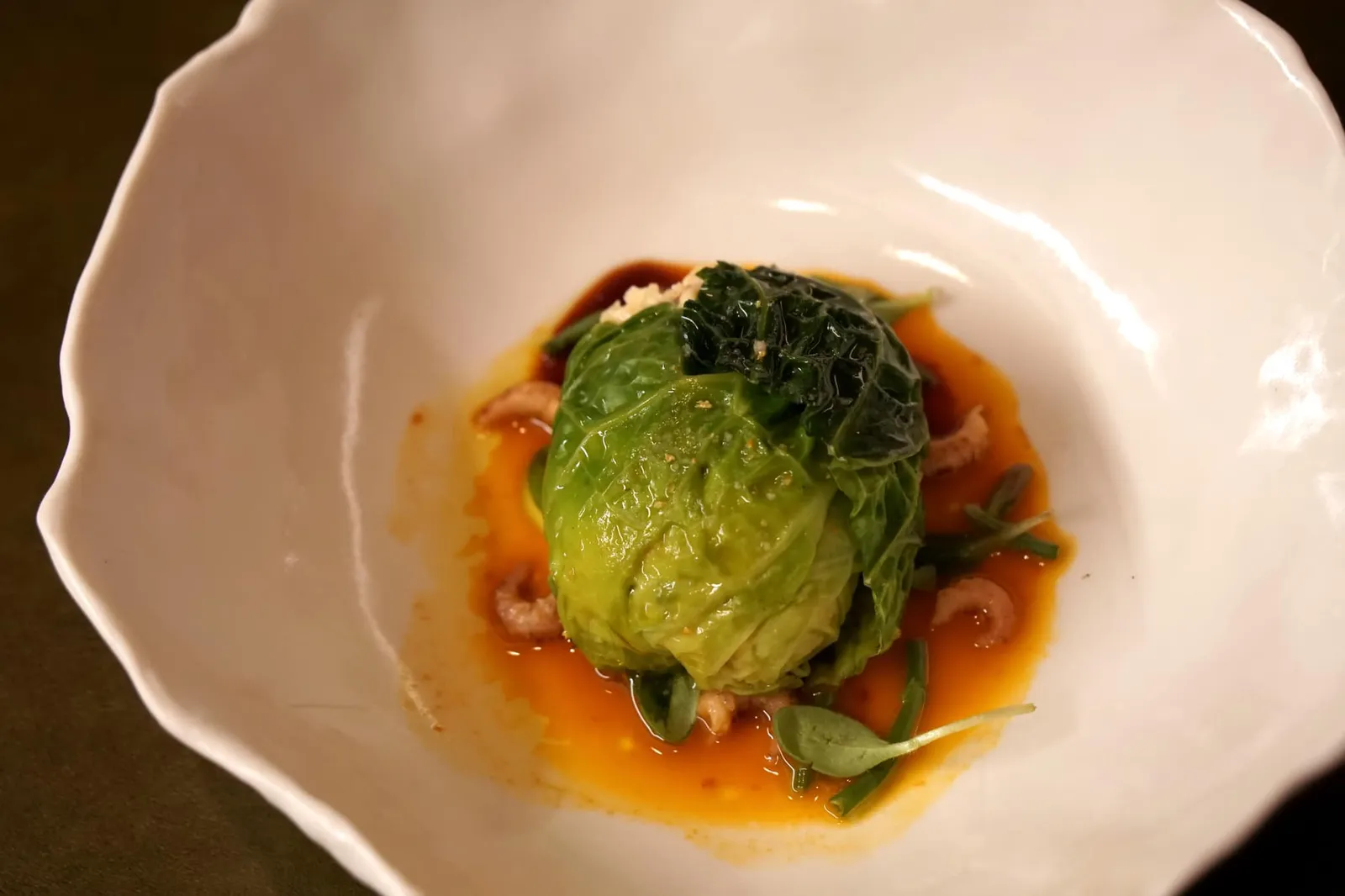 Stuffed cabbage, Mère Fillioux mousseline, seabuckthorn juice, clementine oil ก่อนจะเข้าสู่รายละเอียดของจานนี้ต้องนอกเรื่องไปเกริ่นถึงประวัติของ Mère Fillioux กันเสียก่อน Mère แปลว่า Mother เป็นคำศัพท์ภาษาฝรั่งเศสที่ใช้เรียกหญิงสาวที่มีความสามารถโดดเด่นในการปรุงอาหาร (คล้ายกับที่บ้านเราเรียกให้เกียรติผู้อาวุโสที่มีหน้าที่ทำอาหารที่บ้านเช่น แม่วันนี้มีอะไรทาน) โดยหนึ่งใน Mère ที่มีชื่อเสียงที่สุดคือ Mère Fillioux หญิงสาวจากหมู่บ้าน Auvergne ผู้ซึ่งภายหลังกลายเป็นหนึ่งในเชฟที่ทรงอิทธิพลที่สุดในเมืองหลวงทางอาหารของฝรั่งเศสอย่างกรุง Lyon สูตรอาหารของคุณเเม่ยังคงเป็นเเม่เเบบเเละพัฒนาต่อเนื่องสู่เชฟยุคปัจจุบัน (17/20) ปล. Bresse Chicken Cooked in a Bladder 'a la Mère Fillioux' เมนูซิกเนเจอร์ของ Paul Bocuse สุดยอดเชฟสามดาวมิชลินระดับตำนานผู้ที่ถูกขนานนามว่าเป็น Pope of French cuisine ที่ใช้เนื้อไก่ปรุงมาในกระเพาะปัสสาวะหมูก็ได้สูตรมาจากคุณเเม่ Mère Fillioux นี่ล่ะ โดยเอกลักษณ์ของจานดั้งเดิมของคุณเเม่คือการใช้มีดสองเล่มในการตัดกระเพาะไก่ออกมา หนึ่งในมีดสองเล่มนั้นปัจจุบันยังจัดเเสดงอยู่ที่ Escoffier Museum ในเเคว้น Provence