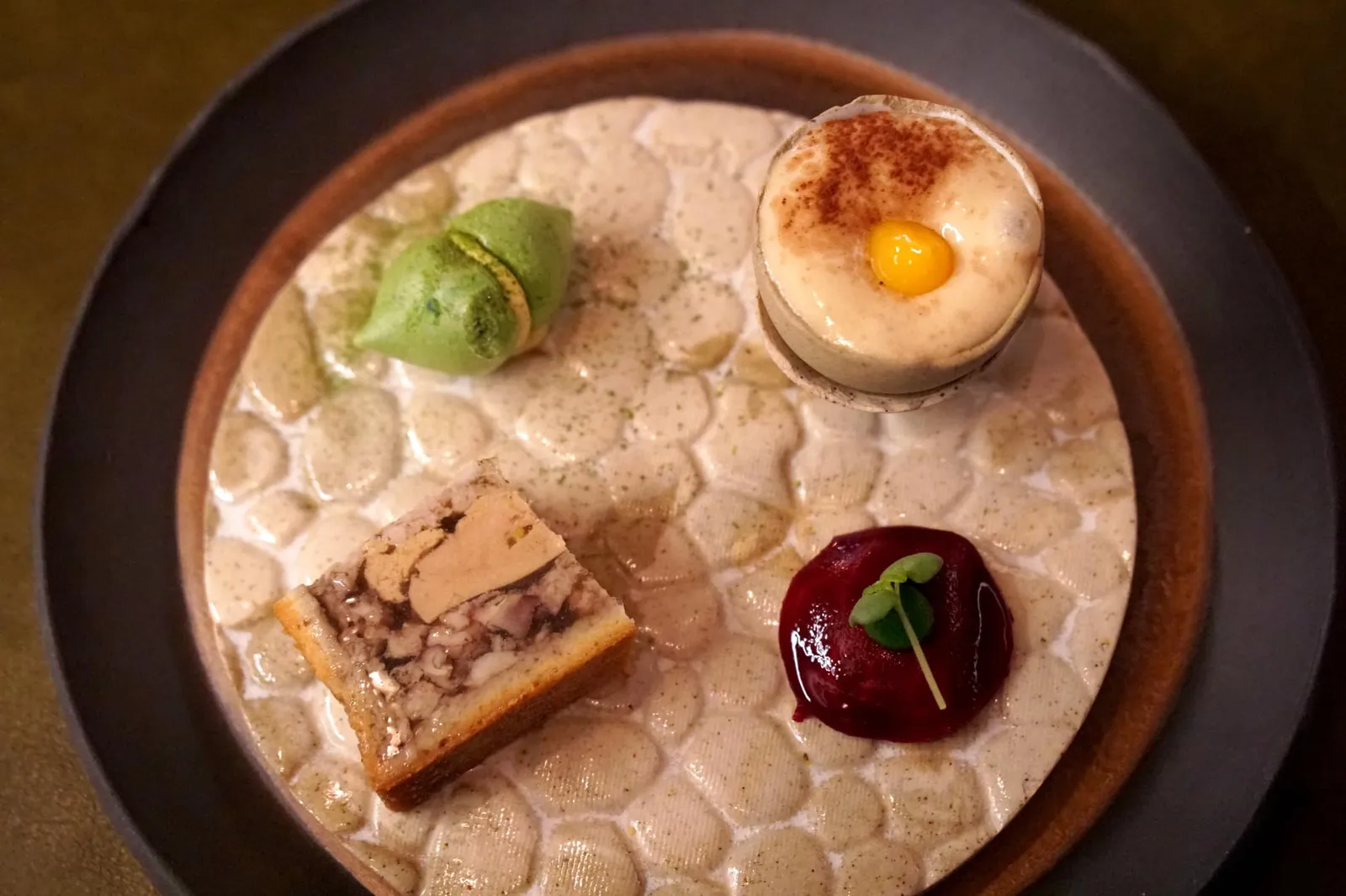 Les Amuse-Bouches, avec l’instant « charcutier » เริ่มต้นมื้ออาหารด้วยอมูสบูช 4 อย่างเริ่มจากด้านล่างคือ Pâté en croûte ทำจากตับห่านผสมกับเนื้อไก่ ผิวขนมปังกรอบกำลังดี ไม่เเข็ง ตับห่านไม่คาว เนื้อเเน่น เนียน เสิร์ฟมาที่อุณหภูมิห้อง ไม่เย็นจนเกินไป (17/20) ฝั่งซ้ายคือ Fennel and cucumber meringue with lemon cream ตัวเมอแรงก์เบา ละลายในปาก มีกลิ่นหอม (17/20) ฝั่งขวาคือ Vegetal ravioli with beetroot and guacamole หรือราวิโอลีทำจากบีมรูท เคี้ยวกรอบ เชฟกำจัดกลิ่นดินหรือ Earthy flavor ของบีทรูทออกไปได้ทั้งหมด ตรงกลางคือกัวคาโมเล่เนื้อเนียนทำมาจากอโวคาโด มีรสเปรี้ยว ช่วยเรียกน้ำย่อยได้อย่างดี (17/20) สุดท้ายด้านบนคือ Cappuccino with potato เป็นมันฝรั่งหั่นเต๋า เเละครีมมันฝรั่ง มีกลิ่นหอม ละมุน เสิร์ฟมาในถ้วยทรงไข่ครึ่งฟอง อร่อยกว่าหน้าตามากๆ (17/20)