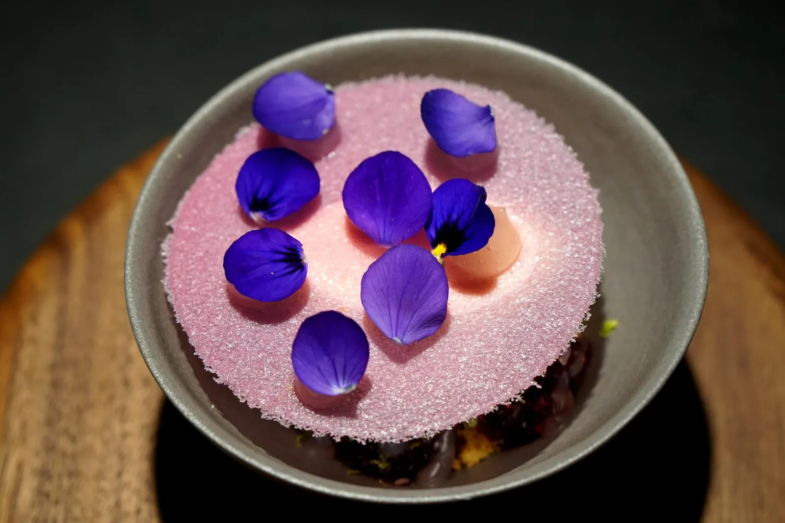 Violet - almond - coconut ปิดท้ายด้วยขนมหวานสีม่วงสวยงาม ด้านล่างมีส่วนผสมของไอศกรีมมะพร้าว อัลมอนด์ครีม ด้านบนคือแผ่นกรอบทำจากดอก Violet สีม่วง ด้านล่างมีเจลลี่ทำจากดอก Violet สีม่วงเช่นกัน กลิ่นที่เด่นที่สุดของจานนี้คือกลิ่นของถั่วอัลมอนด์ (กลิ่นเหมือนกับซุปอัลมอนด์ไข่ขาวที่เป็นขนมหวานในห้องอาหารจีนกวางตุ้งมากๆ) เสริมด้วยกลิ่นของมะพร้าว ตอนทานพนักงานเเนะนำให้ตักทานให้ครบทุกองค์ประกอบของจาน อร่อย สดชื่น ปิดท้ายมื้ออาหารได้อย่างลงตัว (19/20)
