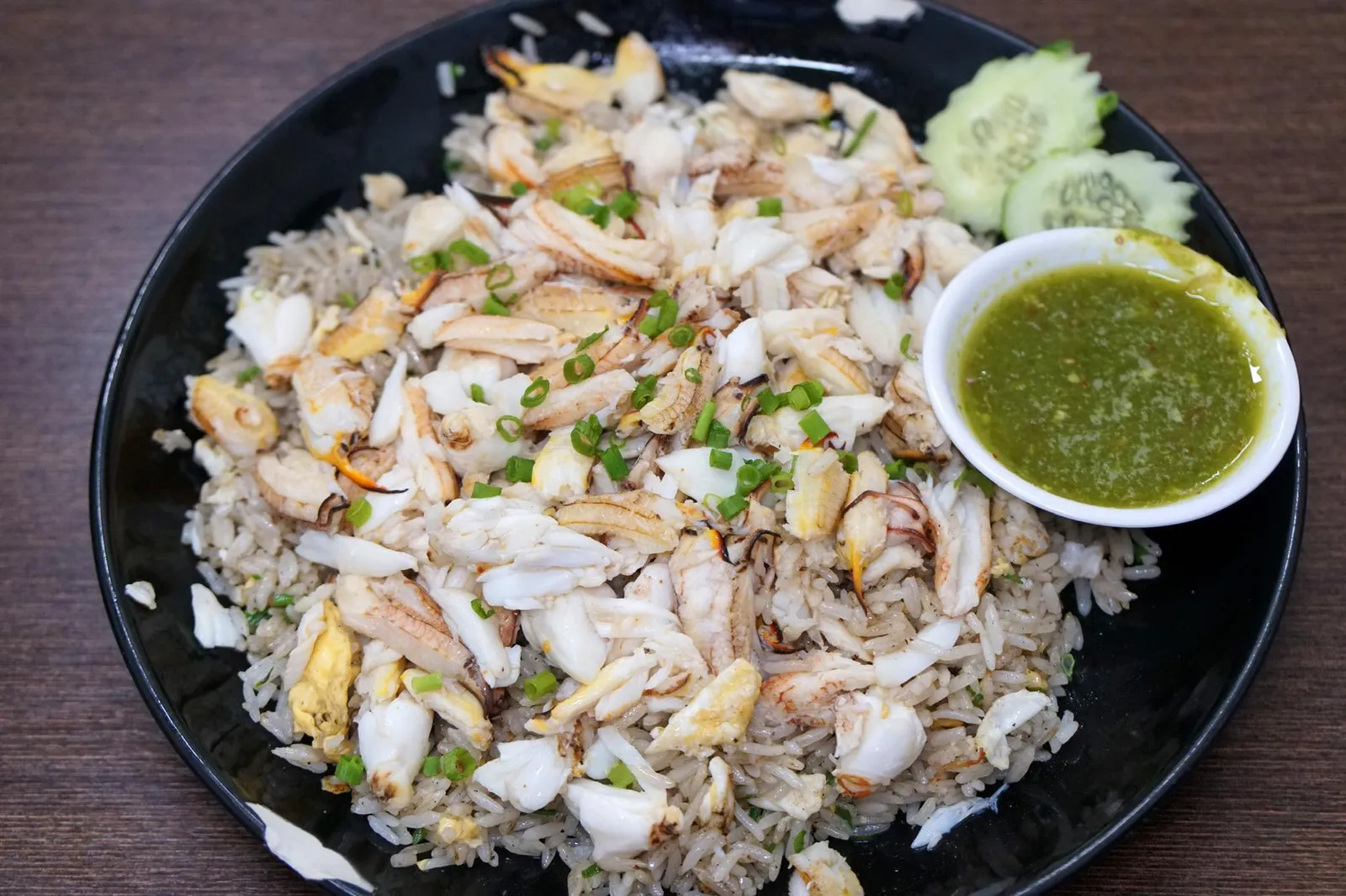 ข้าวผัดโคตรปู (กรรเชียงปูม้า+ก้ามปูม้า) เอ็กซ์ตร้าแครบ (440) Insane Crab Fried Rice Extra Crab มาร้านเฮียให้ทุกคนต้องสั่งเมนู Signature Dish อย่างข้าวผัดโคตรปู โดยเราได้สั่งเพิ่มปูเข้าไปอีกในราคา 100 บาท ! ทางร้านเลือกใช้ข้าวหอมมะลิจากจังหวัดสุรินทร์ ผัดด้วยไฟแรงจนเมล็ดข้าวแห้ง ร่วน ไม่อมน้ำมัน ทั้งยังหอมกลิ่นกระทะ Wok Hei ! มากๆ ในส่วนของเนื้อปูทางร้านได้มาจากจังหวัดสุราษฎร์ธานี เรามั่นใจว่าทางร้านต้องผัดเนื้อปูเเยกกันกับข้าวอย่างแน่นอนเพราะเนื้อปูยังคงสด หวาน ไม่เเห้งเหนียว เนื้อปูที่สังเกตได้จะมีสองส่วนคือกรรเชียงปูทรงสามเหลี่ยมชิ้นโต กัดเเล้วได้ความเป็นปูสะใจ อีกส่วนหนึ่งคือเนื้อก้ามปูซึ่งมีรสหวานนำมากกว่าส่วนอื่นๆอย่างชัดเจน อย่าลืมลองทานกับน้ำจิ้มซีฟู้ดรสเลิศ สูตรที่นี่จะไม่ได้เผ็ดนำจนเเสบลิ้นเเต่จะค่อนข้าวกลมกล่อม หอม ตัดกับความมันของข้าวผัดได้เป็นอย่างดี (15/20)