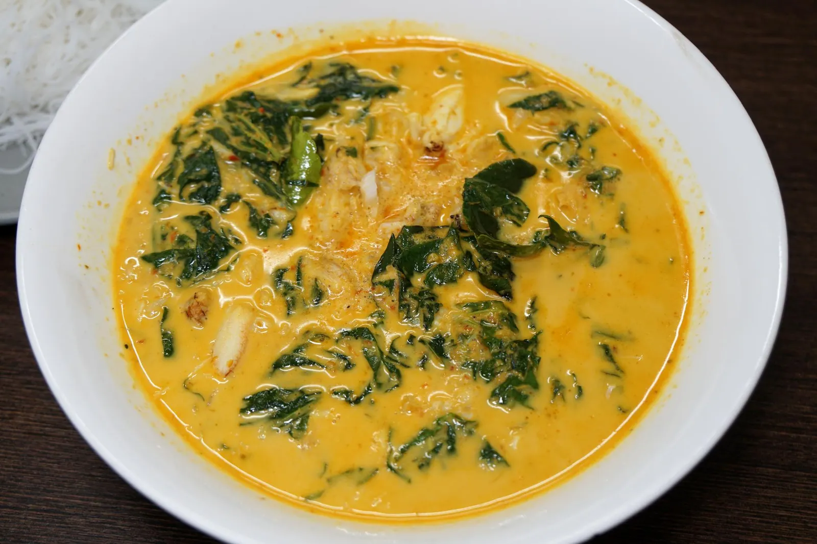 แกงปูใบชะพลู+เส้นหมี่ (380) Thai Southern Crab Curry with Rice Vermicelli นอกจากเมนูผัดต่างๆแล้วเมนูแกงทางร้านก็มีให้เลือกสั่งเช่นกัน แกงปูใบชะพลูเสิร์ฟมาเเบบบ้านๆเเต่รสชาติสูสีระดับเดียวกับห้องอาหาร Fine Dining แกงปูมันๆ มีรสหวานนิดๆ เเซมด้วยรสเค็มหน่อยๆ รสชาติพอจัดจ้านเเต่ไม่เผ็ดจนเกินไป เนื้อปูสดหวาน จานนี้อร่อยมากจนต้องขอยกคะเเนนให้เท่าเทียมกันกับข้าวผัดปูเเละข้าวไข่ข้นเลย ใครไม่สั่งถือว่าพลาดมากๆ (14/20)