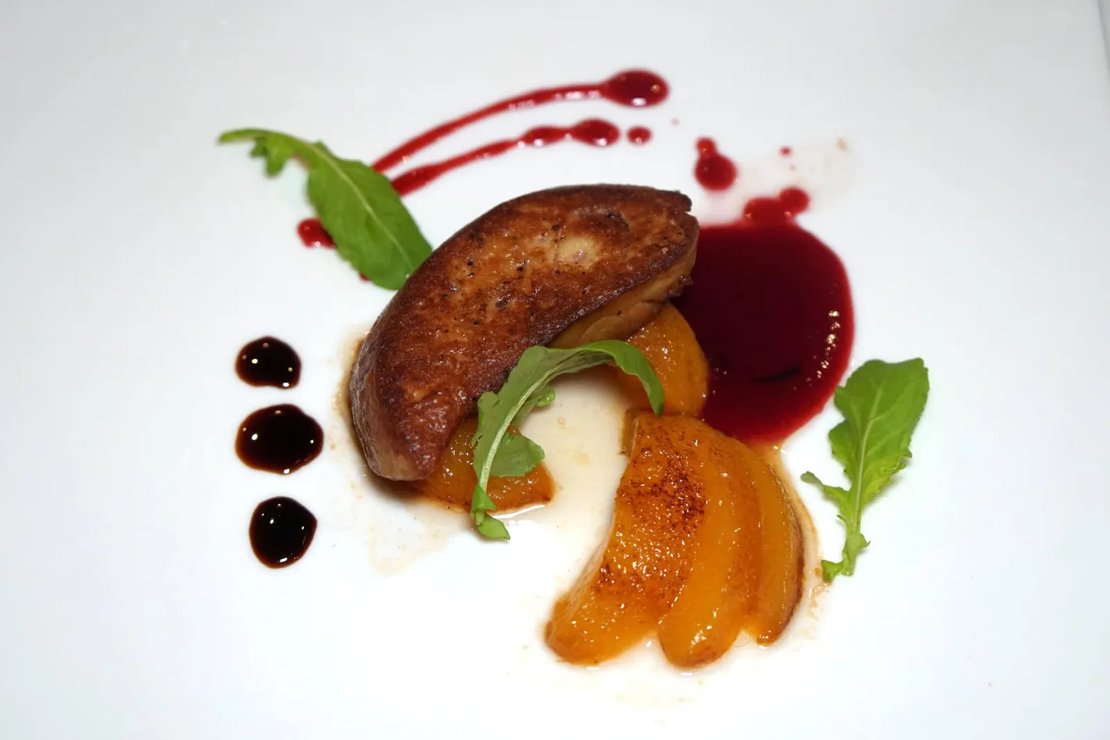 Pan Fried Foie Gras (790++) French foie gras served with caramelized peaches, raspberry and port wine sauce สำหรับ “ฟัวกราส์” เชฟคัดเลือกตับห่านคุณภาพนำเข้าจากประเทศฝรั่งเศสโดยตรงนำไปแพนเซียจนผิวด้านนอกเต่งตึงแต่ด้านในหอม มัน ครีมมี่ จับคู่กับซอสราสเบอร์รี่และพอร์ทไวน์รีดัคชั่นสุดคลาสสิค ข้างกันคือบัลซามิครีดัคชั่น ยังมีลูกพีชที่ผ่านความร้อนจนเกิดการคาราเมลไลซ์มาอย่างพอเหมาะพอดีให้ทานสลับกัน