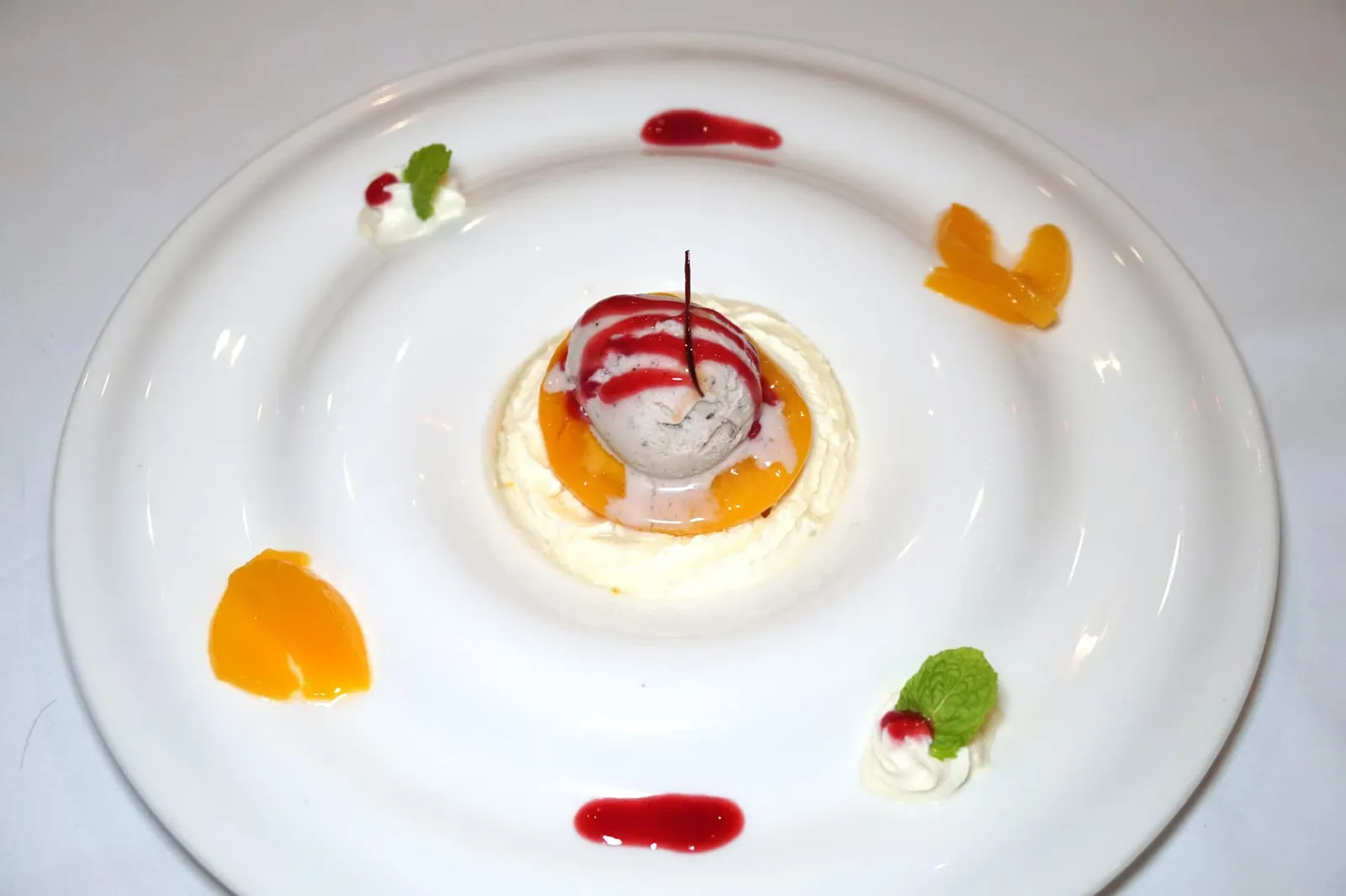 Poached Peaches (240++) With with whipped cream, truffle ice cream and raspberry sauce จานนี้เชฟนำ “ลูกพีช” หั่นเป็นชิ้นบางๆ นำไปโพชจนนุ่ม ด้านล่างรองด้วยวิปปิ้งครีม ด้านบนทอปด้วยทรัฟเฟิลไอศกรีมและซอสราสเบอร์รี่ ตักทุกองค์ประกอบทานพร้อมกันจะได้เนื้อสัมผัสความนุ่มของลูกพีช กลิ่นอโรม่าจากไอศกรีมทรัฟเฟิล ความหอมมันของวิปปิ้งครีม โดยมีรสเปรี้ยวเบาๆจากซอสราสเบอร์รี่เพื่อบาลานซ์รสชาติโดยรวมให้ลงตัวพอดี