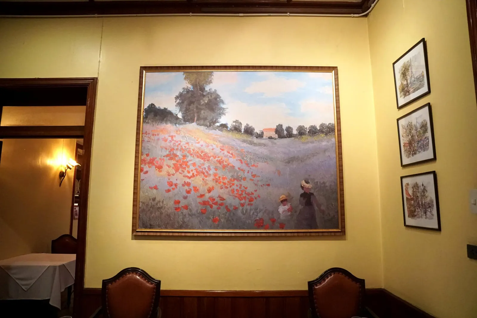บนผนังมีภาพวาดสีน้ำของประเทศฝรั่งเศสแขวนประดับเอาไว้