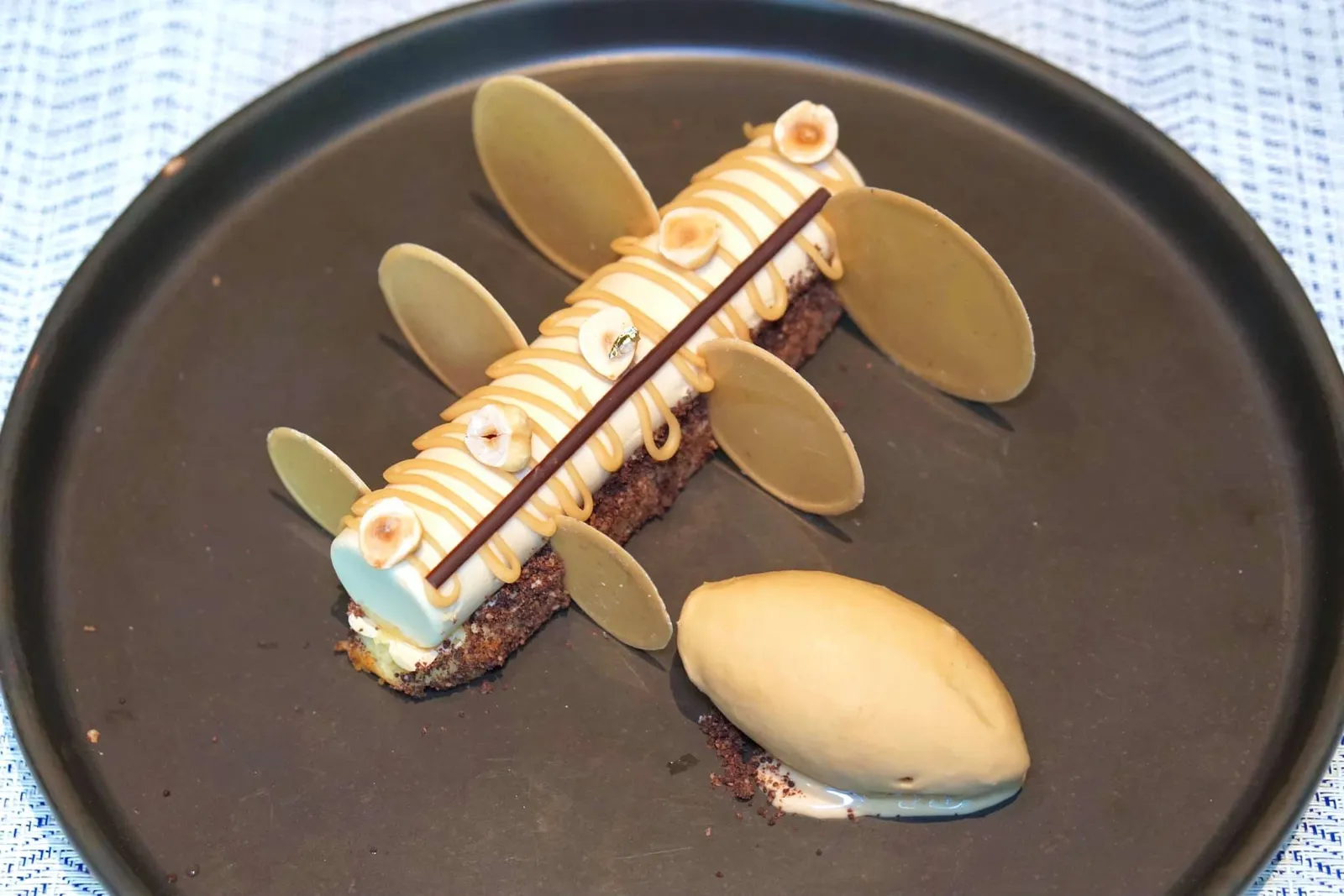 Hazelnut Coffee (290++) Hazelnut soft sponge, Dulcey coffee cream, coffee sauce, praline ice cream สำหรับขนมหวานจานแรกคือ “ฮาเซลนัทรอฟฟี่” สปองเค้กด้านล่างทำมาจากถั่วฮาเซลนัท ทอปด้านบนด้วยครีมกาแฟและซอสกาแฟ อย่างไรก็ตามเมื่อตักทานรวมกันทั้งสปองเค้กและครีมด้ด้านบนให้เนื้อสัมผัสที่ค่อนข้าง thick หรือหนักมากไปนิดสำหรับการเสิร์ฟปิดท้ายมื้ออาหาร ถ้าครีมทำมา Light กว่านี้จะช่วยให้ทานง่ายขึ้นมาก ด้านล่างเป็พราลีนไอศกรีมรสชาติดีไม่เบา (11/20)