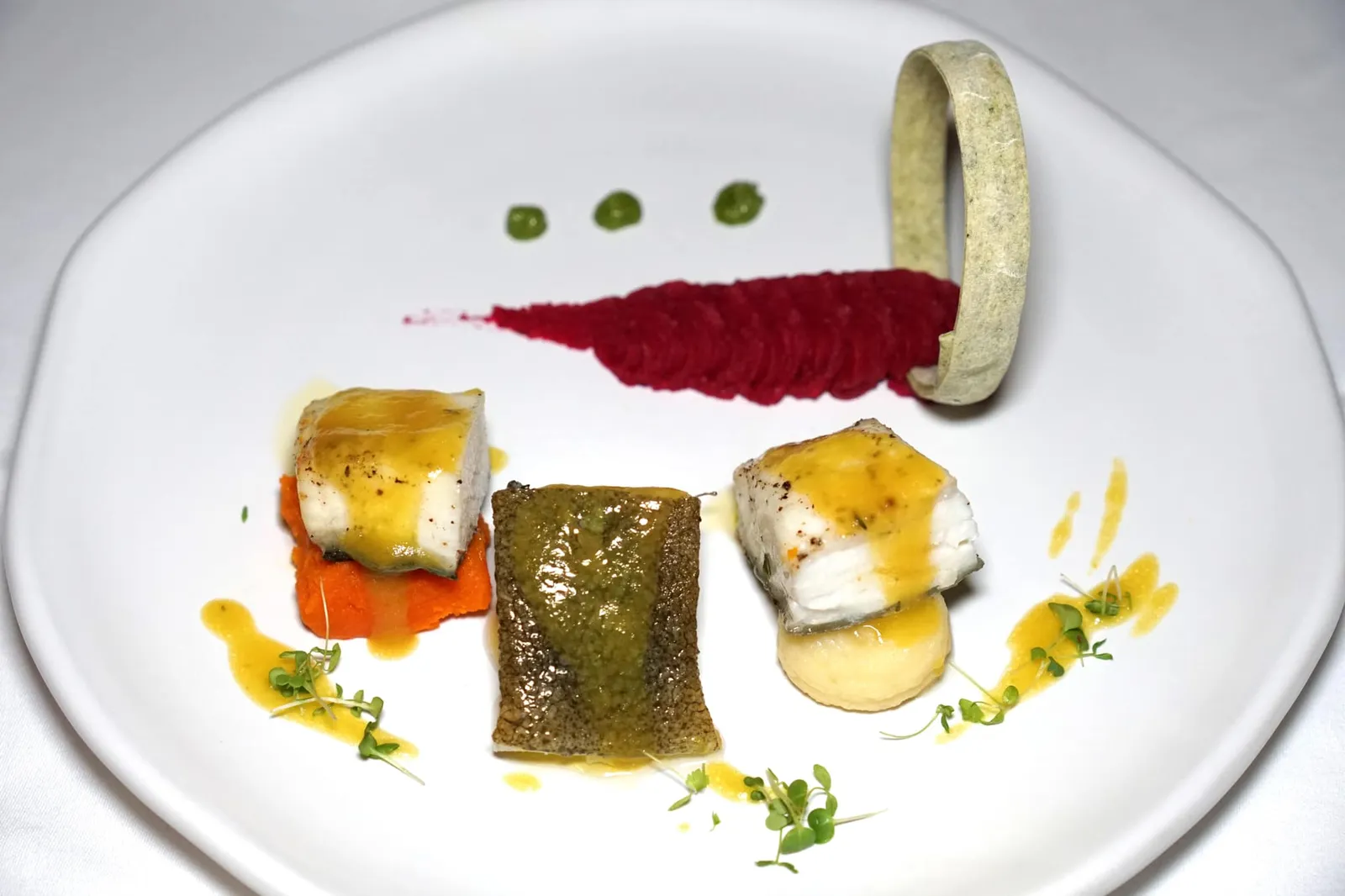 PAN SEARED TURBOT (790++) Ginger Carrot - Mashed Beetroot - Black Ink Purée สำหรับเมนคอร์สเป็น “ปลาเทอร์บอท” นำเข้าจากฝรั่งเศส เชฟนำไปแพนเซียจนสุก เสิร์ฟมากับเครื่องเคียง 3 อย่างเริ่มจากฝั่งขวามือคือแมชโพเทโท่ที่มีกลิ่นหอมของทรัฟเฟิลเด่นชัด ตรงกลางคือพูเรฟักทองและโรสแมรี่ สุดท้ายคือแครอทและขิงฝั่งซ้ายมือ เพื่อน ๆ สามารถทานคู่กับพูเรบีทรูทสีแดงและพูเรร็อกเกตเพสโต้ด้านบน