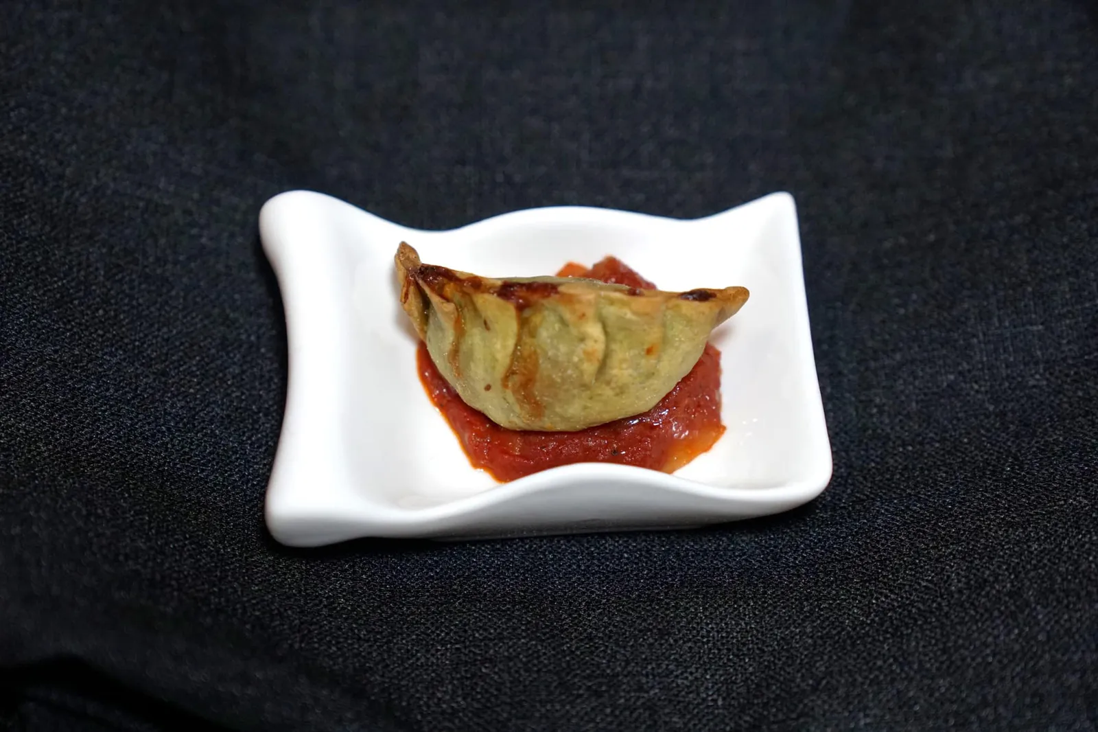 AMUSE BOUCHE เริ่มต้นมื้ออาหารด้วย “อมูสบูช” เชฟใช้แป้งพาสต้าทรงเกี๊ยวกรอบ ห่อหุ้มไส้ด้านในเป็นทำมาจากไก่และผักโขม น้ำซอสด้านอนอกทำมาจากมันฝรั่งและเห็ด