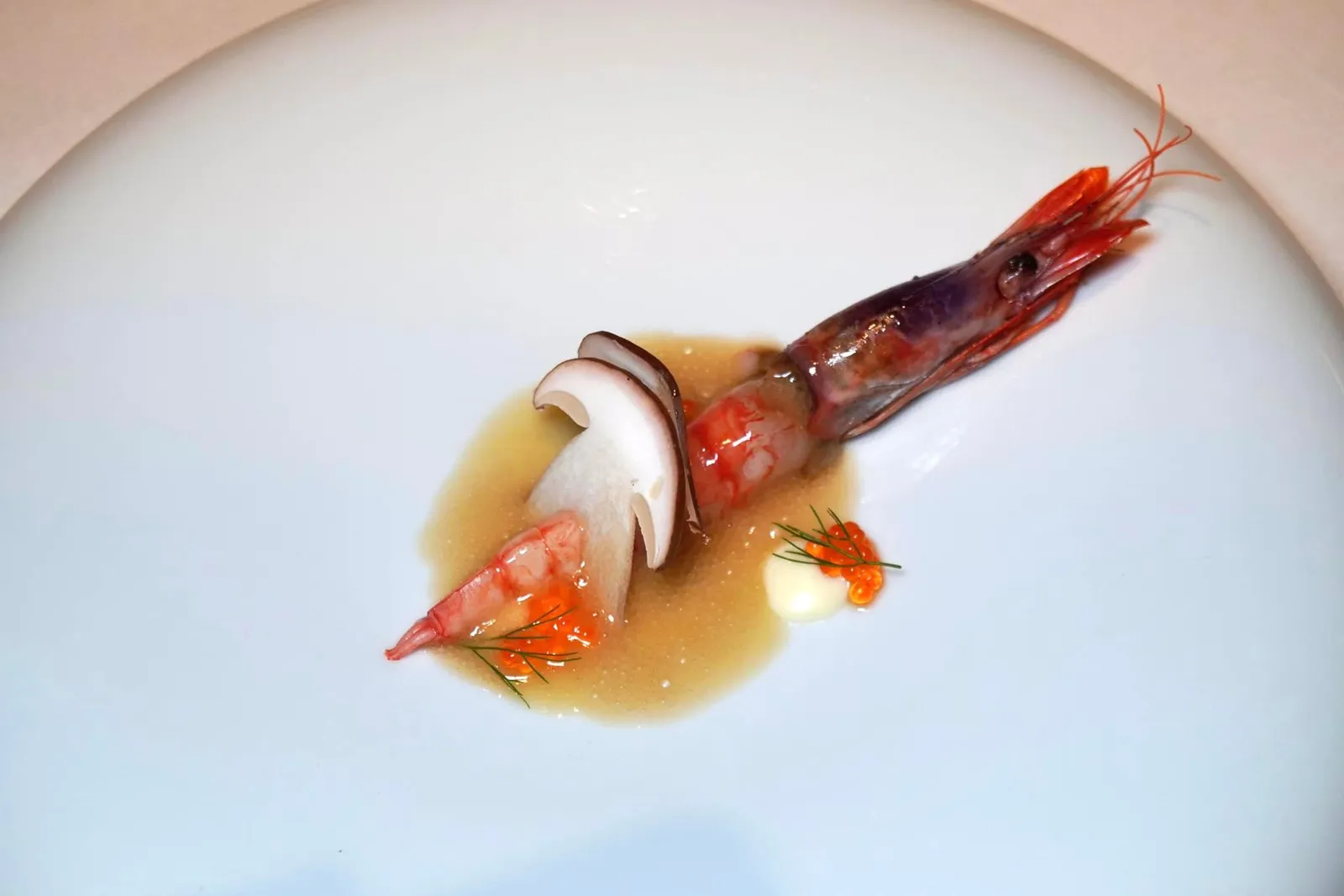 PRODUCTO (2019) RED SHRIMP raw mushroom slices, meuniére and trout roe “โปรดุคโต้” เป็นจานที่ใช้วัตถุดิบหลักคือกุ้งแดงจาก Vilanova i la Geltrú เมืองเล็ก ๆ ไม่ไกลกันจาก Barcelona ในแคว้น Catalonia เป็นองค์ประกอบหลัก เชฟนำส่วนตัวของกุ้งแดงที่เตรียมมาสุกกำลังดี มีความนุ่ม ละมุน รสชาติหวานเด่น เสิร์ฟมากับเห็ดดิบพื้นถิ่นของแคว้น Navarra ที่สไลด์มาเพียงบาง ๆ ช่วยเพิ่มมิติทางเนื้อสัมผัส ด้านล่างคือโฟมทำมาจากซอส Meuniére ที่มีกลิ่นหอมจากเนยเข้ากันดีกับตัวกุ้ง ยังมีไข่ปลาเทร้าต์ที่จะแตกออกในปากเวลาเคี้ยว ไร้ซึ่งกลิ่นคาวใด ๆ หลังจากรับประทานเสร็จให้ใช้มือหยิบองค์ประกอบสุดท้ายซึ่งเป็นพระเอกของจานคือส่วนหัวของกุ้งมาดูดให้ความหอม มัน ขมปลายเบา ๆ อร่อยจนน้ำตาแทบไหลเลยทีเดียว (19/20)