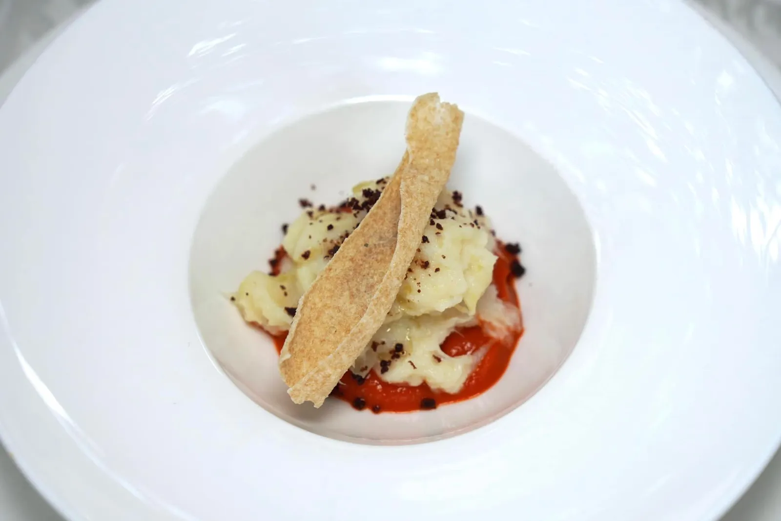 Amuse Bouche เริ่มต้นมื้ออาหารด้วย “อมูสบูช” เป็นเนื้อปลาค็อดที่ทำออกมาให้เนื้อสัมผัสคล้ายสำลี เสิร์ฟมากับพูเรพริกหวานเพื่อชูรสชาติ และมะกอกเสริมกลิ่นให้หอมมากขึ้น (14/20)