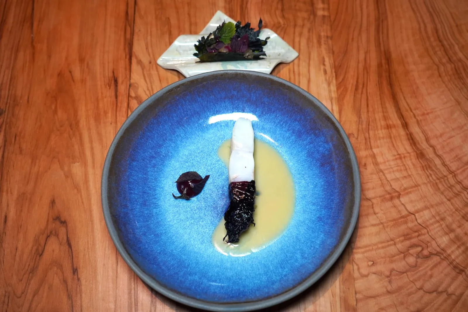 Shiso Fish from the boat จานนี้เกิดจากการจับคู่กันของปลา Turbot กับ Fermented Shiso Leave ที่ผ่านกระบวนการหมักให้เนื้อสัมผัสเคี้ยวหนึบและรสชาติอมเปรี้ยวเบา ๆ ตัดกันกับชิ้นปลา อย่างไรก็ตามด้วยความหนึบของใบ Shiso ทำให้ขณะเคี้ยวชิ้นปลาอาจจะละเอียดไปจนหมดก่อนได้ (19/20)