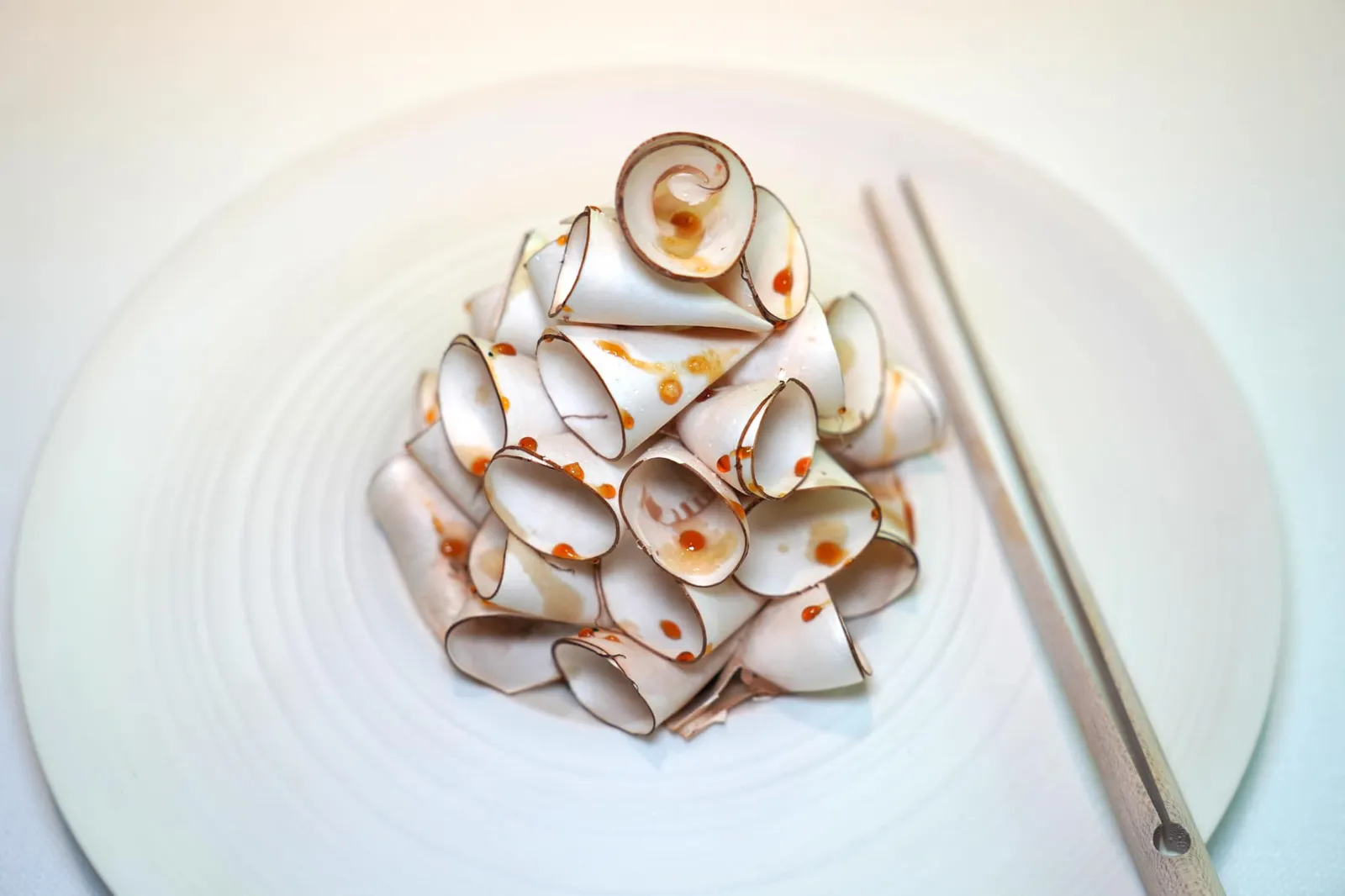 Mushroom salad from Savoie องค์ประกอบแรกคือ Raw Mushroom เห็ดดิบที่ได้รับการฝานเป็นริ้วบาง ๆ ขนาดเท่า ๆ กันให้เนื้อสัมผัสอันโดดเด่นเป็นเอกลักษณ์ ด้านล่างเป็น Confit Mushroom หรือเห็ดที่ผ่านการกงฟีจนนุ่ม ทั้งยังมีความนุ่มละมุนของเจลลี่ จากนั้นแต่งแต้มด้วย Mushroom Vinaigrette จนเห็นเป็นหยดสีส้มกระจายอย่างทั่วถึงกัน (20/20)