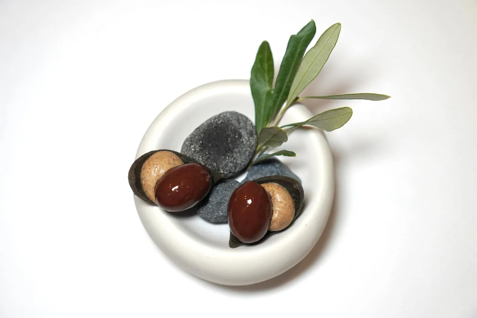 Mignardises ขนม Biscuit กรอบท็อปด้านบนด้วยองค์ประกอบของ Smoked Vanilla, Dark Chocolate Ganache และ Black Olive Tapenade