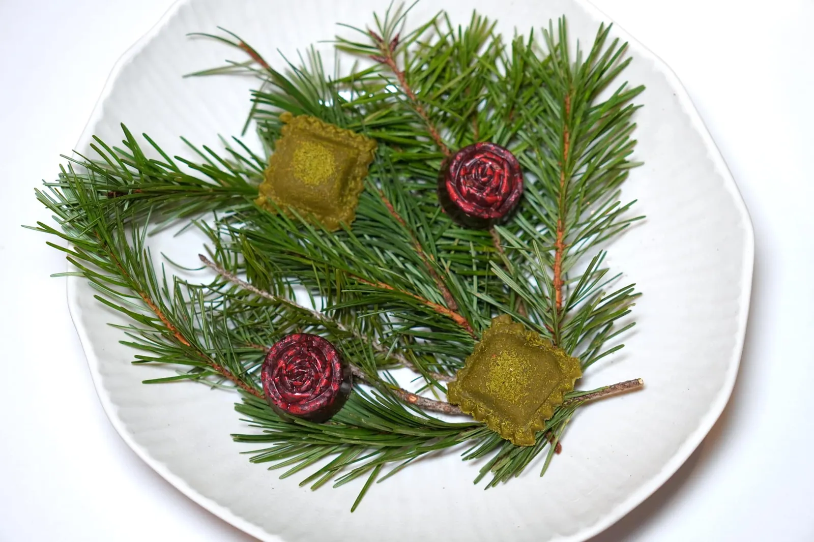 Mignardises Ravioli of Pine Nuts ด้านในสอดไส้ Confit Yuzu อีกชิ้นหนึ่งคือ Rose Chocolate ด้านในสอดไส้ Almonds & Hazelnuts Praline
