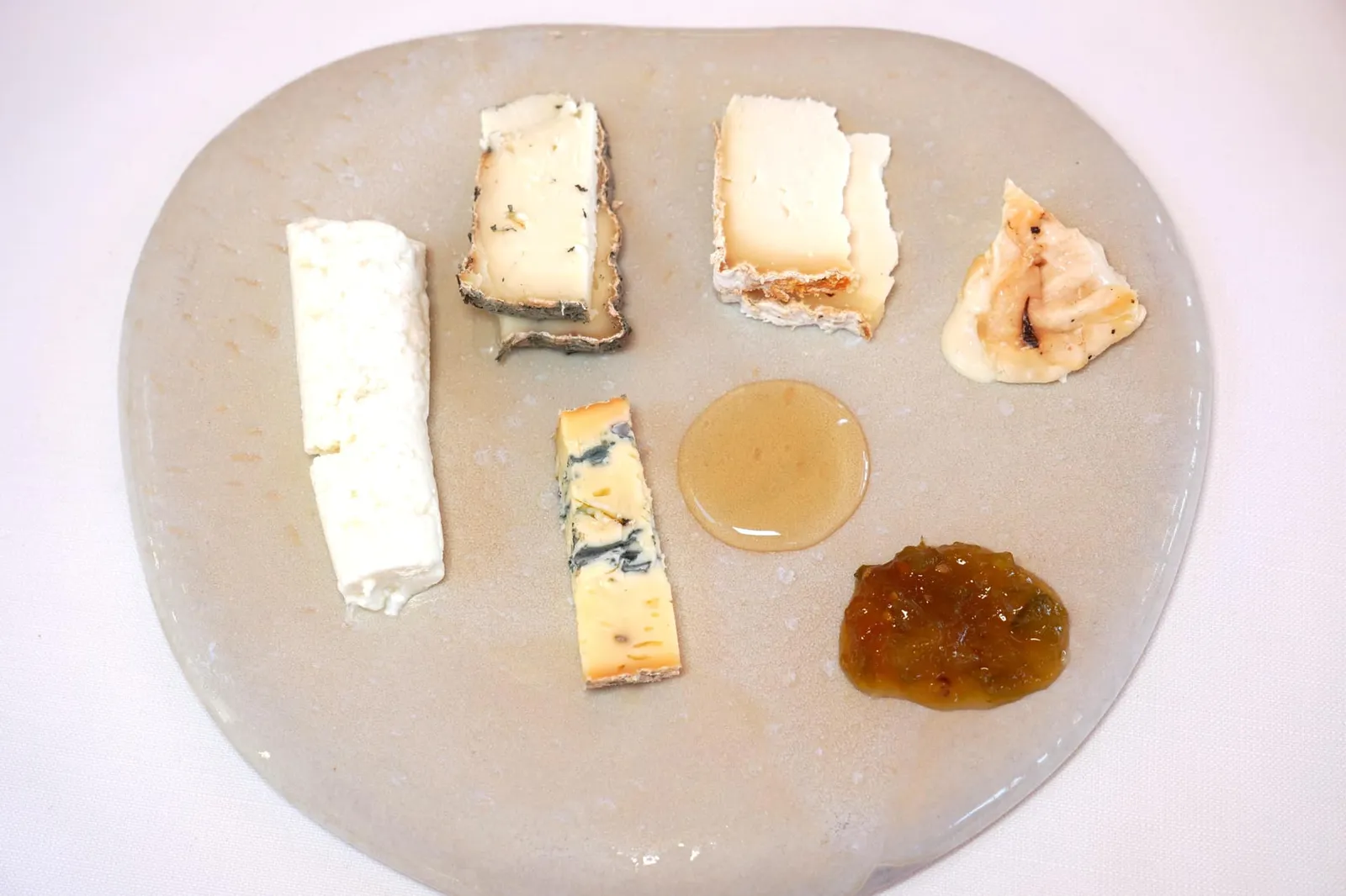 Cheese trolley พนักงานจะเตรียมมาให้ในจานเซรามิคที่ออกแบบโดย Cécile Cayrol จับคู่กับน้ำผึ้งและแยมมะเขือเทศ