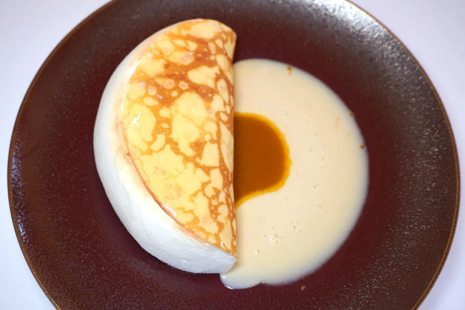 Crêpe soufflé, “History” with the finest Grand Marnier, “In memory of Monsieur Thuilier” อาหารหวานที่อุทิศให้กับ Raymond Thuilier เชฟผู้ก่อตั้ง L'Oustau de Baumanière คือ Crêpe Soufflé ที่เชฟ Brandon Dehan เตรียมแป้ง Crêpe โดยผสมแป้ง, น้ำตาล, เกลือ และไข่เข้าด้วยกัน จากนั้นเติมนมและเนยเหลวลงไปก่อนจะนำไปแช่ไว้ในตู้เย็นนาน 2 ชั่วโมง เตรียมองค์ประกอบของ Soufflé โดยปั่นไข่ขาวและน้ำตาลให้เข้ากัน เติมนม, แป้ง และผิวส้มลงไปแล้วต้มให้เดือด จากนั้นใส่ไข่แดงและ Grand Marnier คุณภาพดีที่สุดเพิ่มไปแล้วต้มให้เดือดอีกครั้ง จบด้วยการใส่องค์ประกอบของไข่ขาวแล้วคนให้เข้ากัน บนกระทะแบบ Non-Srick Pan ให้เทราด Crêpe ลงไปและพับแป้งเข้าหากัน อบจนผิวด้านนอกให้สีน้ำตาลและมีเลเยอร์ความกรอบบาง ๆ ตัดกันกับความนุ่มละมุนจนของ Soufflé ตรงกลาง (20/20)