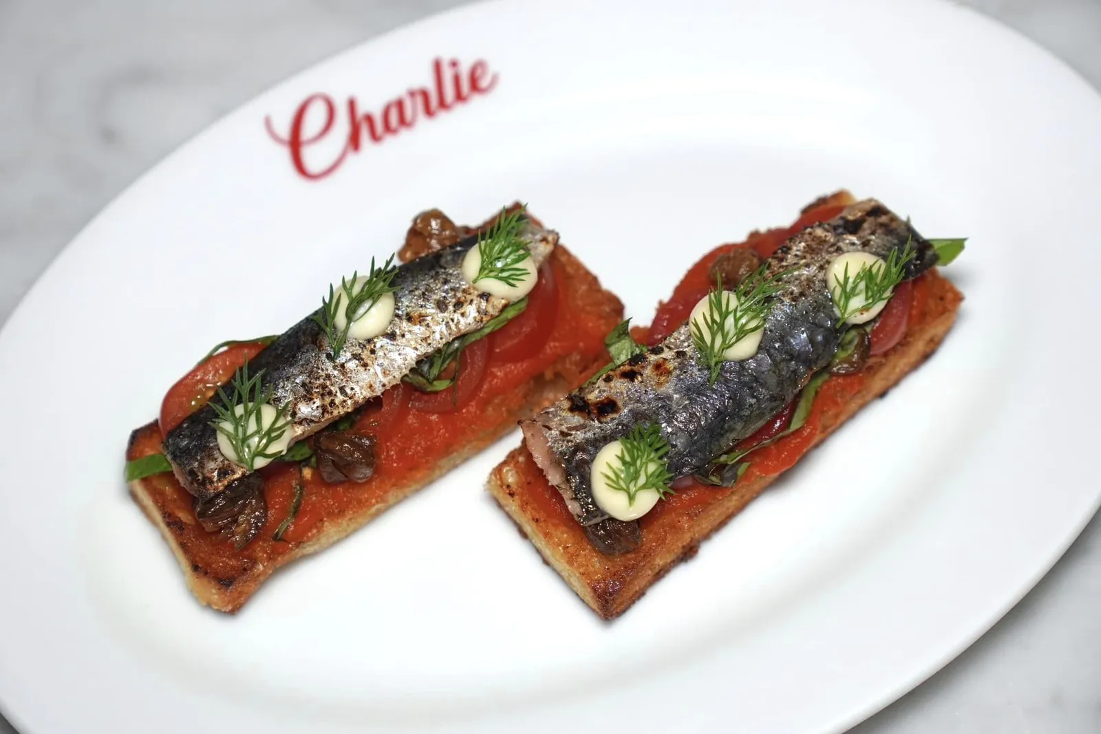 Spanish Sardine on Toast (210++/p) Grilled Spanish sardines, Tomato sauce, Cherries Tomatoes, Caper, Garlic Aioli, Toast ขนมปังโทสต์กรอบ ๆ ท็อปด้านบนด้วยซอสมะเขือเทศและมะเขือเทศเชอร์รี่ ไฮไลท์คือปลาซาร์ดีนนำเข้าจากประเทศสเปนให้รสชาติเค็มและอุมามิ