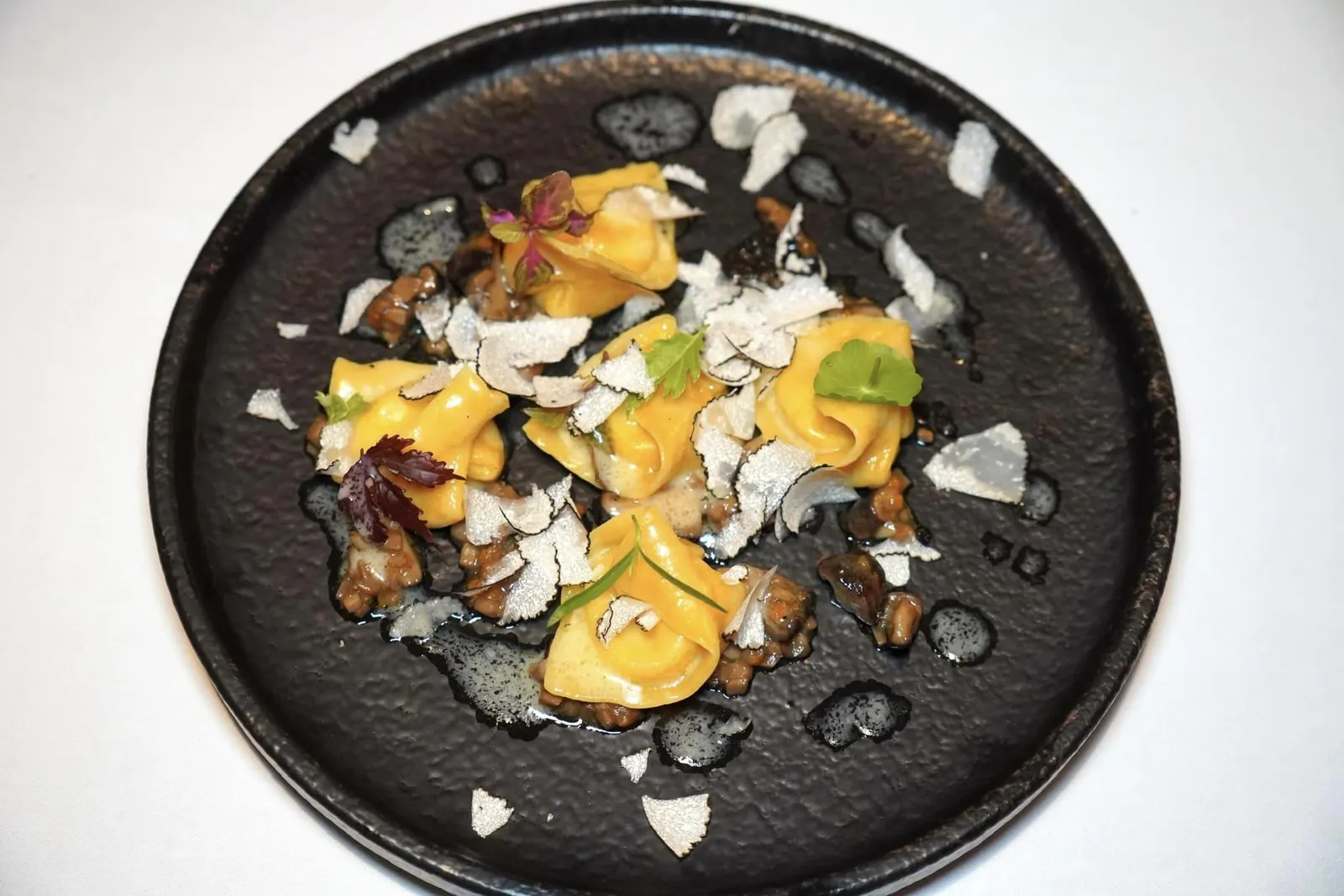 Ravioli Al Tartufo (590++) Handmade Ravioli, Parmigiano, Truffle, Mushroom Ragù เราขอแนะนำให้ลองสั่งหนึ่งในจาน Ravioli ที่ดีที่สุดในกรุงเทพ พาสต้าทรงเกี๊ยวที่ทางร้านทำเอง ภายในบรรจุซอส Ragù เห็ดอุ่น ๆ เสริมด้วยความเค็มที่พอเหมาะด้วย Parmigiano และความหอมของทรัฟเฟิลที่พร้อมจะแตกระเบิดออกในปากขณะเคี้ยว รอบ ๆ คือเห็ดที่สับมาช่วยเพิ่มเนื้อสัมผัสได้ดี นอกจานี้ขณะยกมาเสิร์ฟที่โต๊ะเชฟยังขูด Summer Black Truffle ลงไปจนทั่วจานอีกด้วย