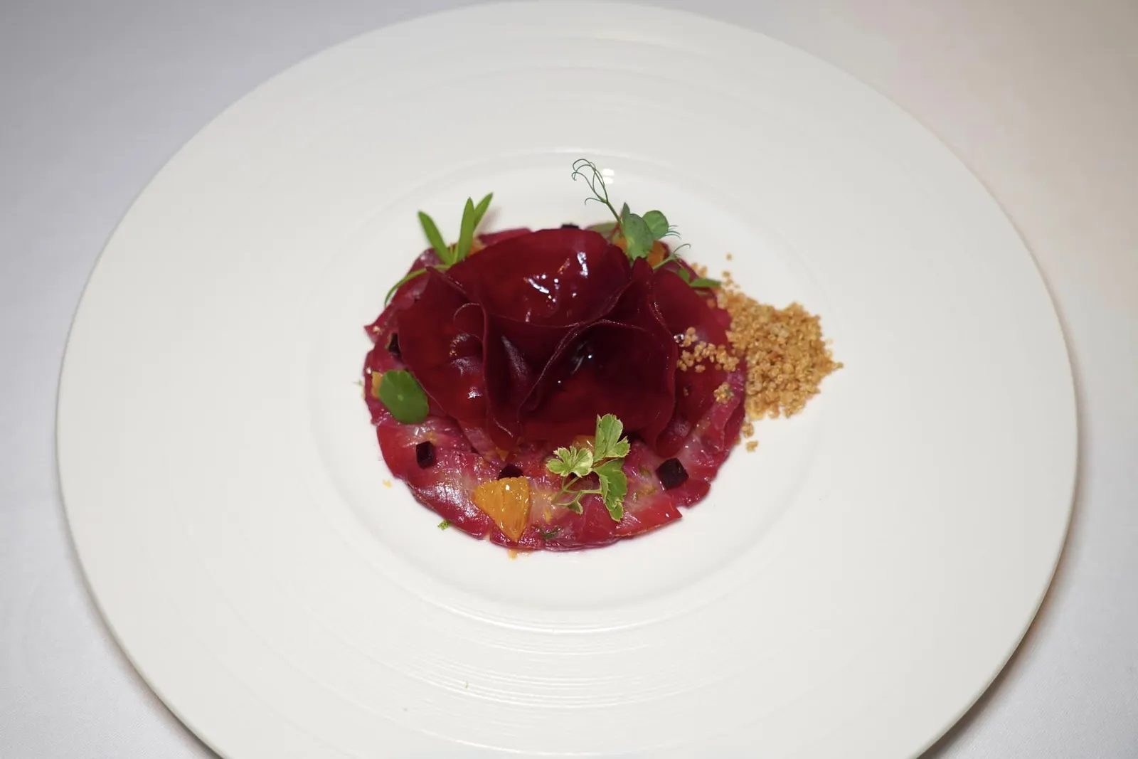 Hamachi Carpaccio (790++) Yellow Tale, Beetroots, Orange, Crispy Quinoa เริ่มต้นจานแรกด้วยปลา Hamachi ที่ผ่านการหมักในน้ำบีทรูท เกลือ ผิวมะนาว และผิวส้มนานถึง 2 วันจนได้สีแดงสด จากนั้นนำมาแล่เป็นชิ้นบาง ๆ หรือที่เรียกว่า Carpaccio ให้เนื้อสัมผัสนุ่มหนึบตัดกันกับองค์ประกอบของแผ่นบีทรูทเปรี้ยวหวานบางกรอบด้านบน นอกจากนี้ยังมีบีทรูทชิ้นสี่เหลี่ยมที่ผ่านการนำไป Slow-cooked จนสุก ข้างกันคือควินัวกรอบ ๆ ช่วยเพิ่มความสนุกขณะเคี้ยวได้นั่นเอง