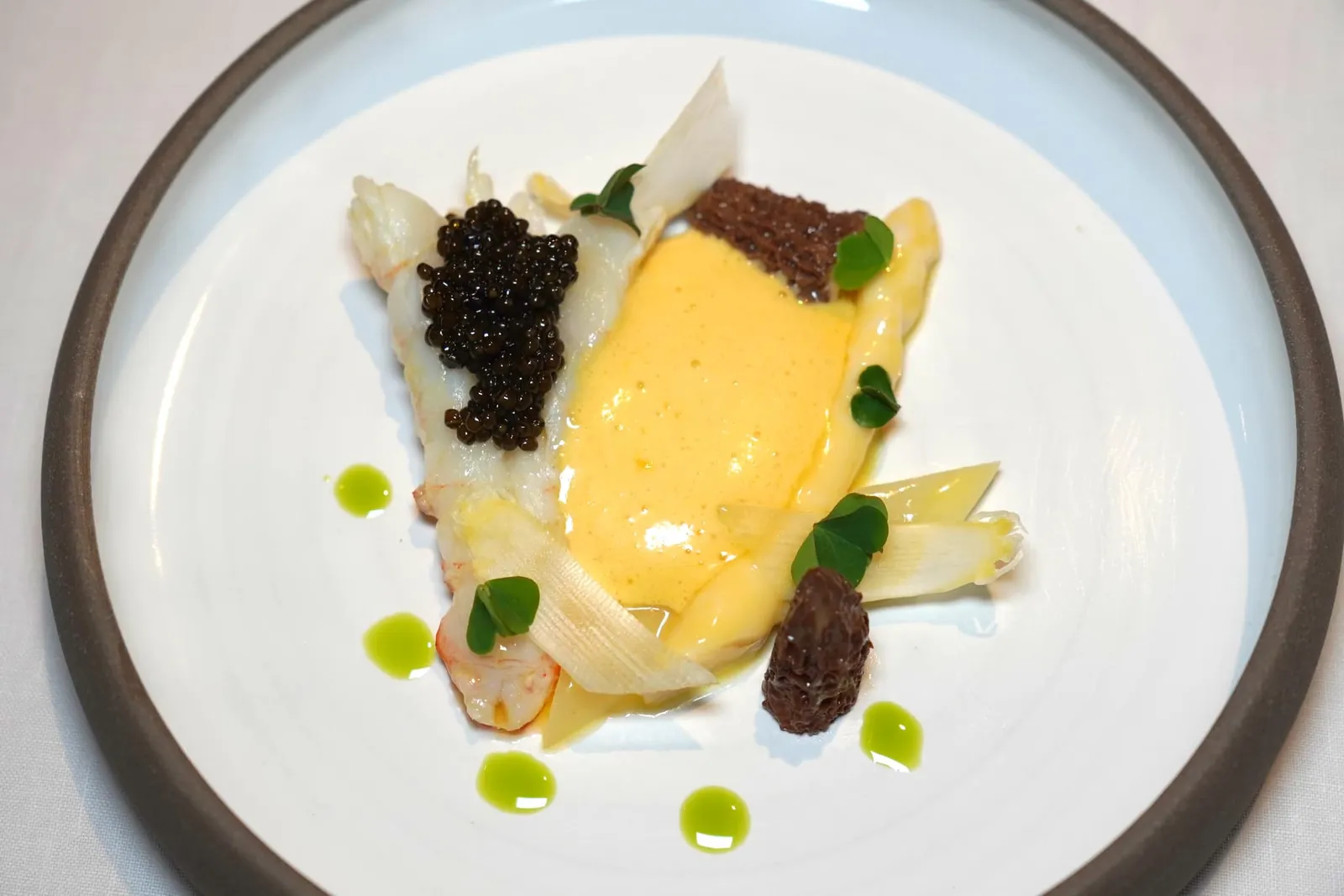 Langoustine / Yellow Wine / Morels Mushrooms / White Asparagus กุ้ง Langoustine ที่ผ่านการคัดขนาดและคุณภาพมาอย่างดีเสิร์ฟมาแบบกึ่งสุกกึ่งดิบสังเกตได้จากเนื้อด้านนอกที่มีความกรอบแต่เรนื้อตรงกลางยังคงฉ่ำหวานเข้ากันกับความเค็มและกลิ่นอายของมหาสมุทรจาก Oscietra Caviar ชั้นดี เชฟเพิ่มมิติทางเนื้อสัมผัสด้วยการใส่ White Asparagus หรือหน่อไม้ฝรั่งขาวที่กำลัง In Season ในทวีปยุโรปเสิร์ฟมาแบบฝานบางเคี้ยวกรอบ นอกจากนี้ยังมี Langoustine Mousse ที่เชฟขึ้นเป็นรูป White Asparagus ให้เนื้อสัมผัสที่เนียนละมุน ยังมีองค์ประกอบของเห็ด Morels เคี้ยวหนึบ ซอสตรงกลางเตรียมมาจาก Vin Jaune หรือ Yellow Wine จากภูมิภาค Jura ในประเทศฝรั่งเศสนั่นเอง (18/20)