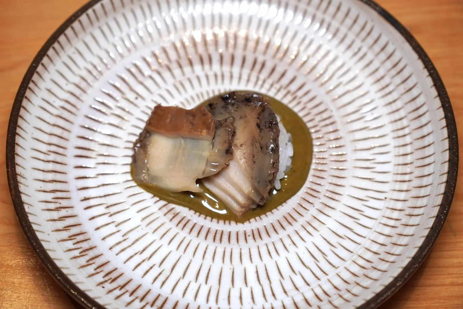 AWABI Abalone from Chiba with Ichizu signature liver sauce เนื้อหอยนึ่งมาสุกกำลังดี มีความหนึบแต่ไม่เหนียว ไม่มีกลิ่นคาวแม้แต่น้อย เชฟแล่มาเป็นชิ้นขนาดพอดีคำ มีริ้วจากการแล่เป็นชั้น ๆ ขนาดเท่า ๆ กันเพื่อให้ยึดน้ำซอสได้ดีมากยิ่งขึ้น ด้านล่างคือ Kimo Sauce ทำมาจากตับหอยจึงมีความครีมมี่ หอม มัน เข้ากันกับข้าวและเนื้อหอยได้อย่างไร้ที่ติ