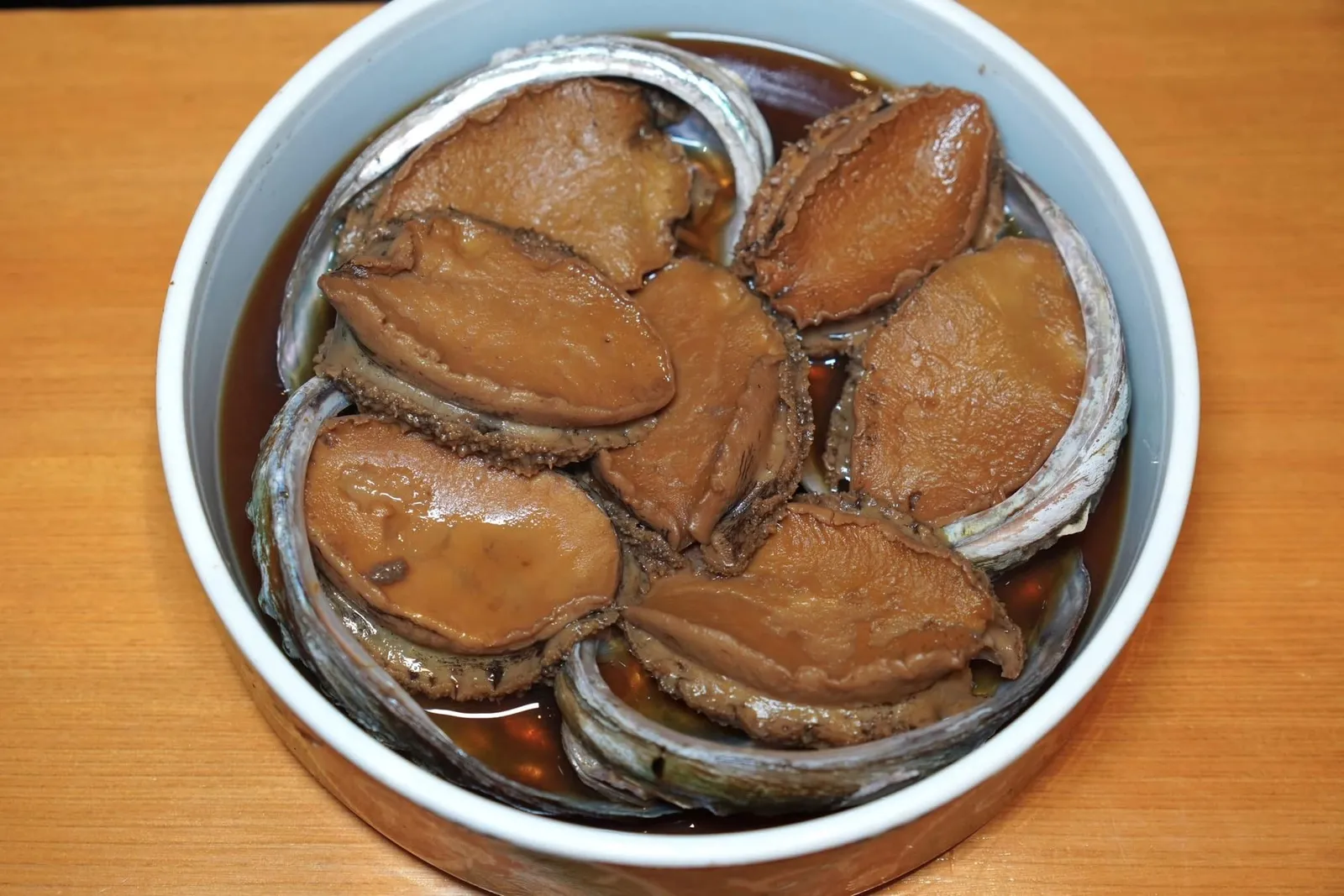 AWABI Abalone from Chiba with Ichizu signature liver sauce ในภาพคือวัตถุดิบพรีเมี่ยมอย่าง “อะวาบิ” หรือหอยเป่าฮื้อญี่ปุ่นจากจังหวัด Chiba ที่ผ่านการนึ่งกับสาเกเป็นระยะเวลานานถึง 4-6 ชั่วโมง ในที่นี้เชฟจะนำมาแสดงให้ดูก่อนจะนำไปแล่ หากสังเกตให้ดีจะพบว่าเชฟพิถีพิถันกระทั่งการแล่เนื้อหอยให้เป็นริ้วคลื่นเพื่อให้จับตัวกับน้ำซอสได้ดีมากยิ่งขึ้น