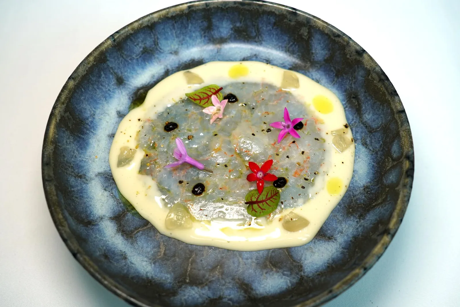 Gambes blanques amb all blanc Blue belly shrimp, almond and garlic soup, grapes Gambes Blanques หรือกุ้งขาวท้องน้ำเงินตามภาษา Catalan เสิร์ฟมาแบบดิบโดยการทุบและรีดให้แบนเป็นแผ่น รอบ ๆ คือซอสที่เตรียมมาจากนมอัลมอนด์และกระเทียมปรุงรสด้วยความเปรี้ยวของเกรปฟรุตและความหวานของชิ้นองุ่น ด้านบนคือองค์ประกอบของกระเทียมดำช่วยเติมแต่งกลิ่นให้ออกมามีเอกลักษณ์ (13/20)