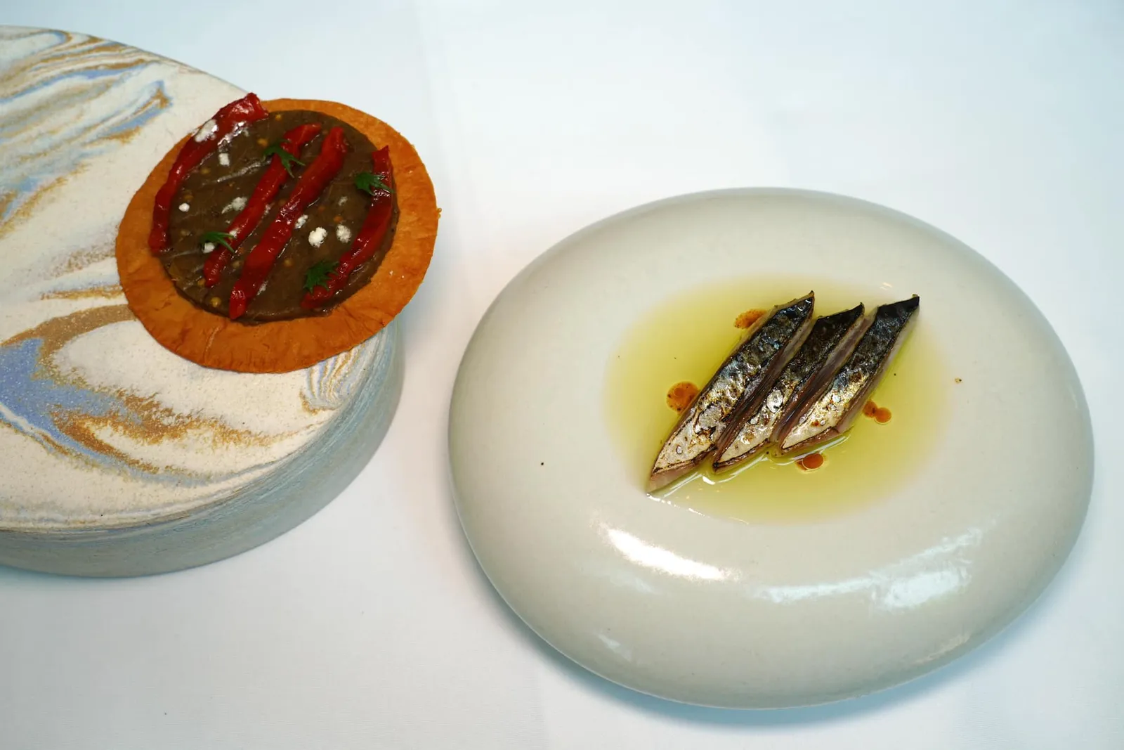 Coca de recapte Mackerel, pepper, eggplant, filo จานนี้พนักงานแนะนำให้คีบชิ้นปลา Mackerel ที่ผ่านการย่างเสิร์ฟมากับน้ำมันมะกอก EVO จากประเทศสเปนวางลงบนแป้ง Filo บางกรอบ เมื่อแรกเคี้ยวเราจะสัมผัสได้ถึงความนุ่มและขมเบา ๆ ของมะขือและพริกหวานเตรียมมาในรูปแบบของ Purée นอกจากนี้ยังมีผงสีขาวละเอียดที่เตรียมมาจากน้ำมันมะกอกอีกด้วย (14/20)
