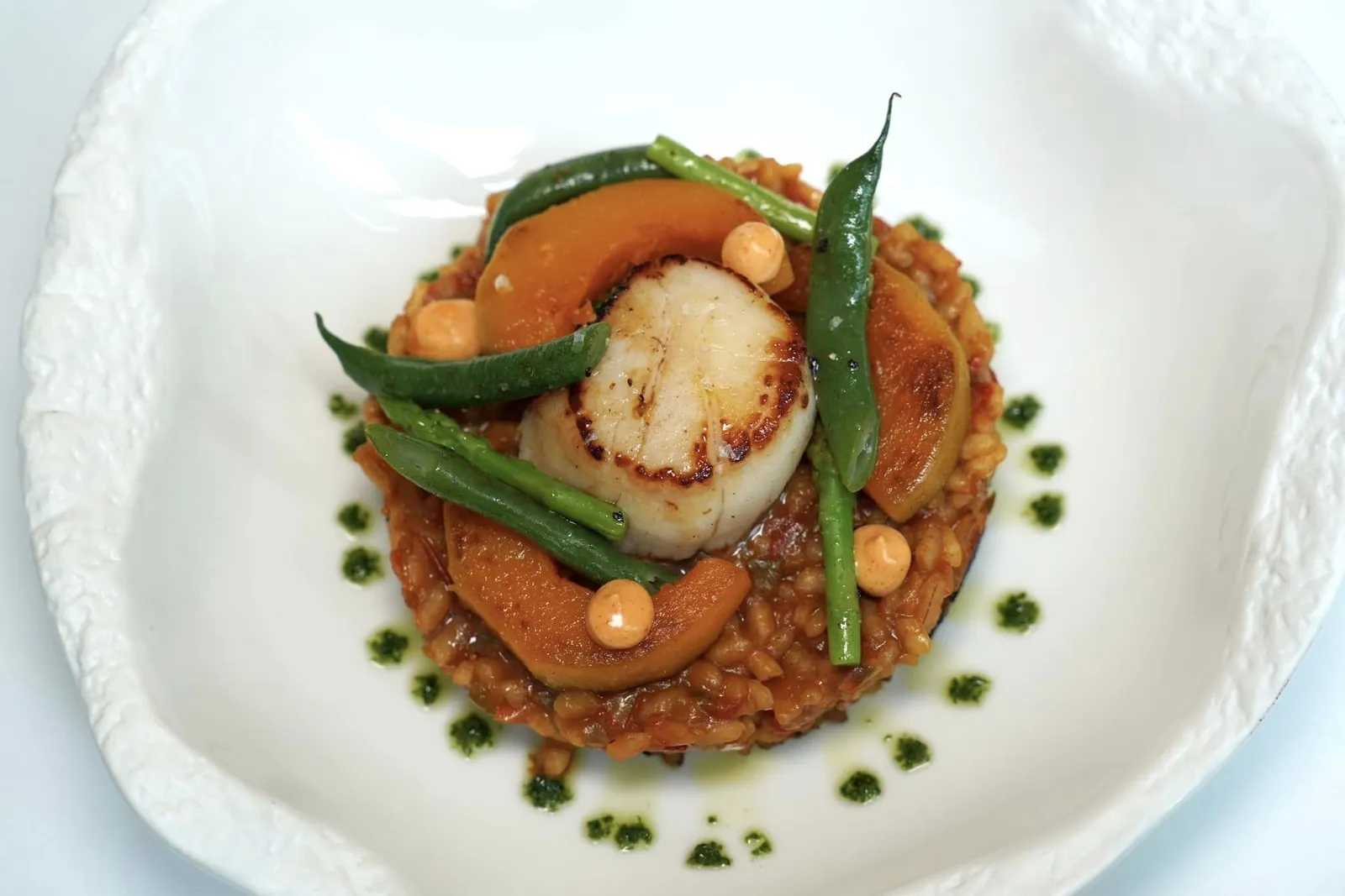 Arròs sec amb vieira i espàrrecs Scallop, bomba rice, asparagus จานนี้เชฟเลือกใช้ข้าวสเปนสายพันธุ์ Bomba คลุกเคล้ากับซอสจากหัวกุ้งในกระทะจนสุกโดยตัวข้าวมีบางส่วนที่ไหม้ตามแบบฉบับที่ชาวสเปนรับประทานกัน รอบ ๆ คือองค์ประกอบของน้ำมันพาสลีย์ ด้านบนคือหอยเชลล์โฮตาเตะจากฮอกไกโดจับคู่กับผักต่าง ๆ (13/20)