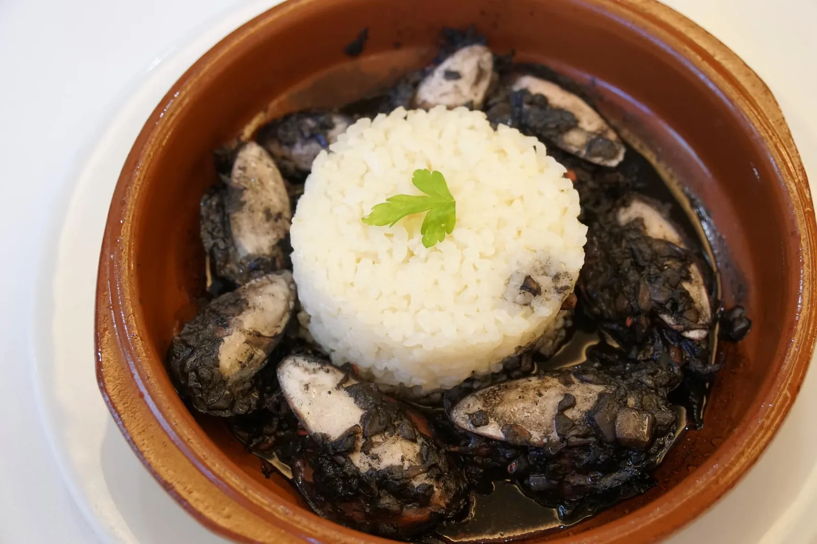 Choquitos de la ría en su tinta de arroz (13.50) Ría cuttlefish in its ink with rice สุดท้ายคือเมนูอาหารท้องถิ่นอย่างข้าวสเปนทานกับปลาหมึก แและหมึกดำจากตัวหมึกเอง ข้าวสเปนนั้นเป็นข้าวกลุ่ม short grain rice จะมีเนื้อสัมผัสนุ่มหนึบออกไปทางข้าวญี่ปุ่นเเต่ไม่เหนียวเท่า ทานกับหมึกดำของหมึกที่ทางร้านทำออกมาดีมากๆ ไม่มีกลิ่นคาวใดๆ เนื้อหมึกนุ่ม จัดเป็นเมนูพื้นบ้านที่อร่อยใช้ได้เลยทีเดียว (14/20